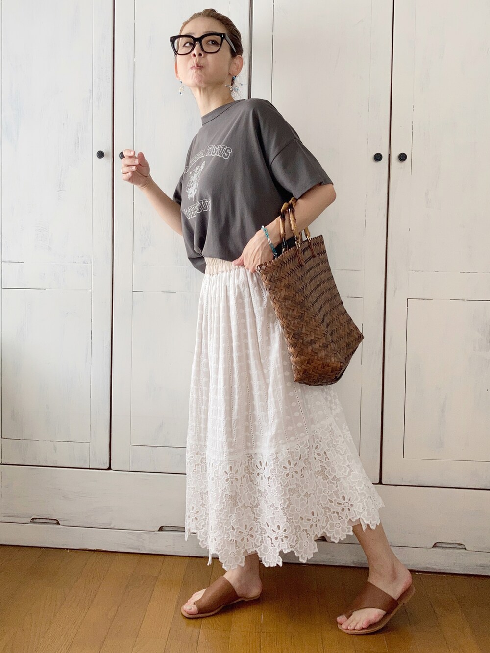 グレー系のTシャツ/カットソー、ホワイト系のスカート、ブラウン系のかごバッグを着用したレディースの夏コーディネートの2枚目の写真