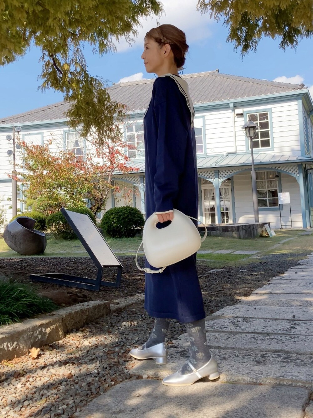 ブルー系のワンピース/ドレス、ホワイト系のバッグ、シルバー系のパンプスを着用したレディースの秋コーディネートの4枚目の写真