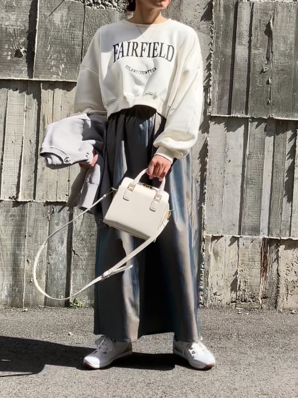 ホワイト系のスウェット、グリーン系のスカート、ホワイト系のハンドバッグを着用したレディースの春コーディネートの3枚目の写真