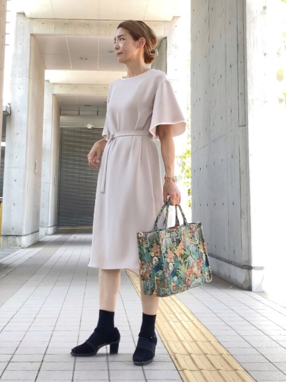 ベージュ系のワンピース、ブラック系のサンダル、その他のトートバッグを着用したレディースの秋コーディネートの2枚目の写真