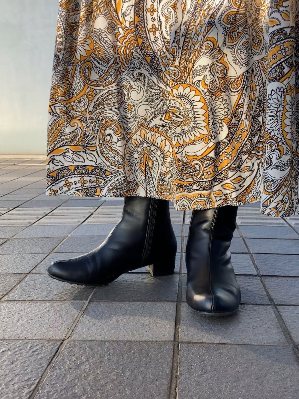 ベージュ系のニット/セーター、イエロー系のワンピース、ブラウン系のショルダーバッグを着用したレディースの秋コーディネートの2枚目の写真