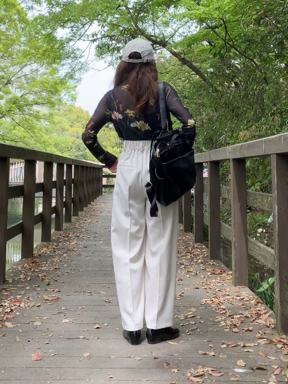 ホワイト系のその他パンツ、ブラック系のTシャツ/カットソー、ブラック系のシューズを着用したレディースの春コーディネートの2枚目の写真