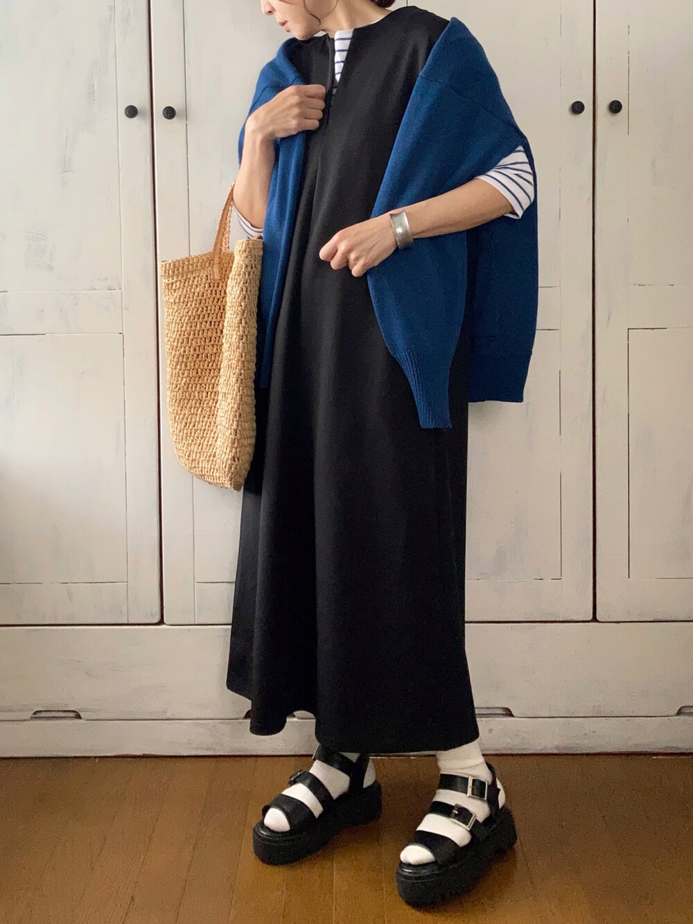 ブラック系のワンピース、ブルー系のカーディガン/ボレロ、ブルー系のTシャツ/カットソーを着用したレディースの春コーディネートの2枚目の写真