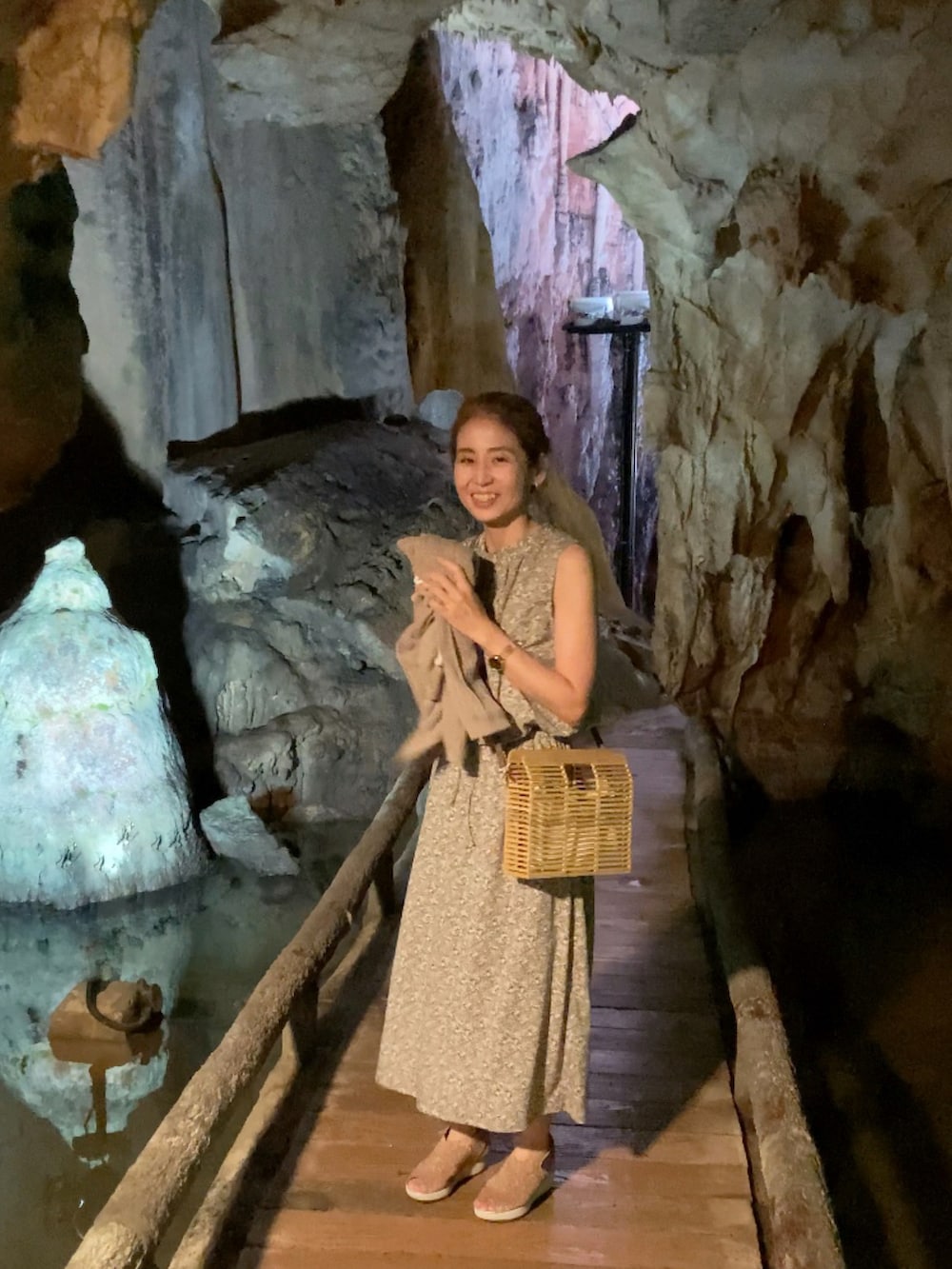 グリーン系のワンピース、ベージュ系のかごバッグ、ゴールド系のサンダルを着用したレディースの夏コーディネートの2枚目の写真