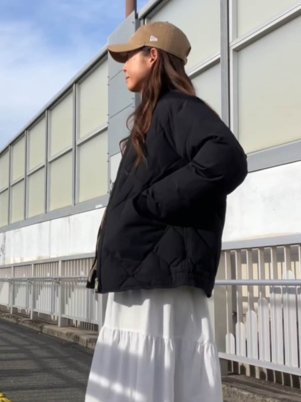 ブラック系のダウンジャケット/コート、ベージュ系のキャップを着用したレディースの冬コーディネートの2枚目の写真