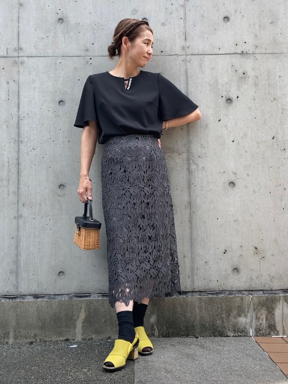 ブラック系のシャツ/ブラウス、イエロー系のサンダル、ブラウン系のかごバッグを着用したレディースの春コーディネートの3枚目の写真