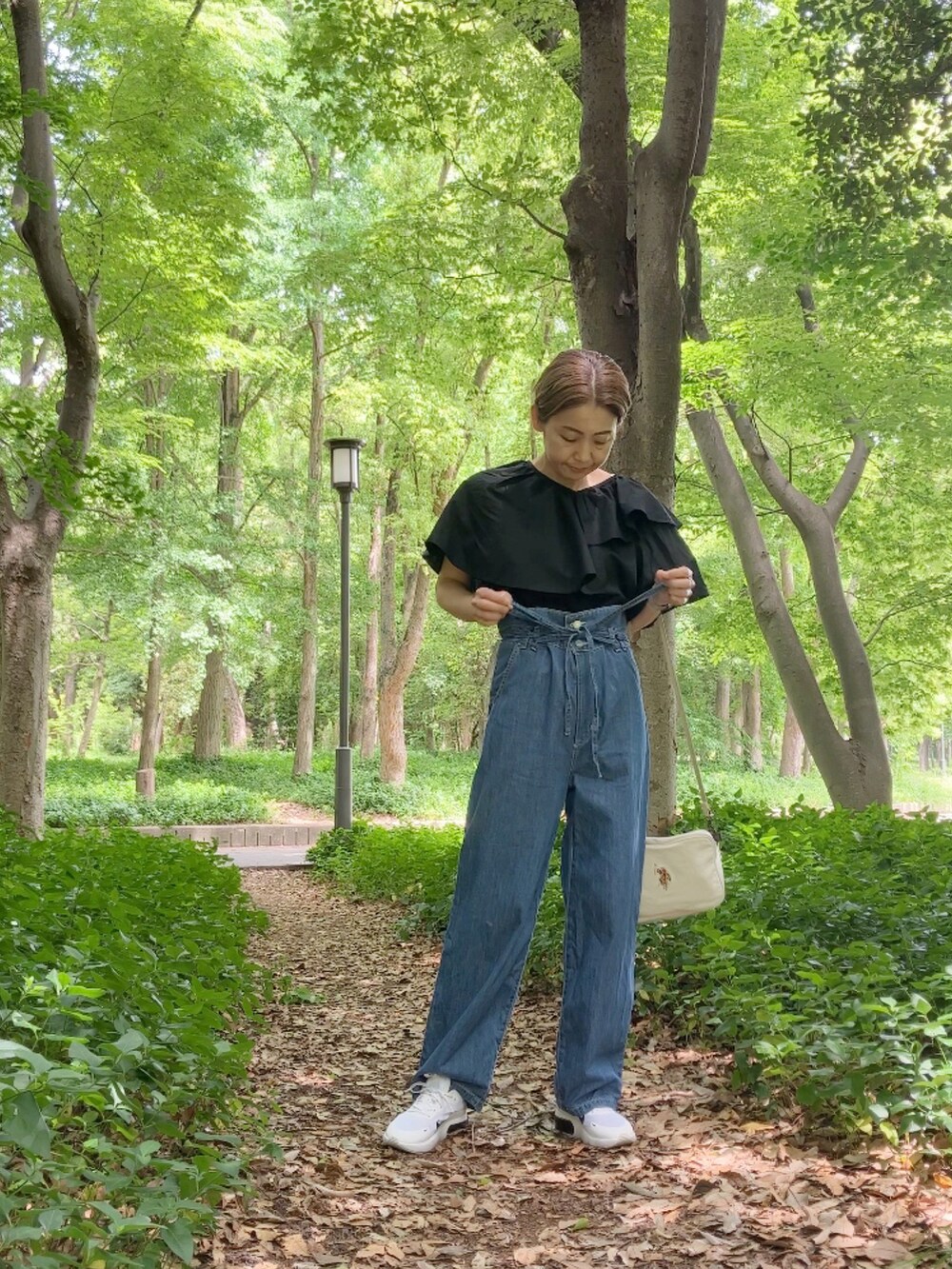 ブラック系のシャツ/ブラウス、ブルー系のサロペット/オーバーオール、ホワイト系のショルダーバッグを着用したレディースの春コーディネートの2枚目の写真