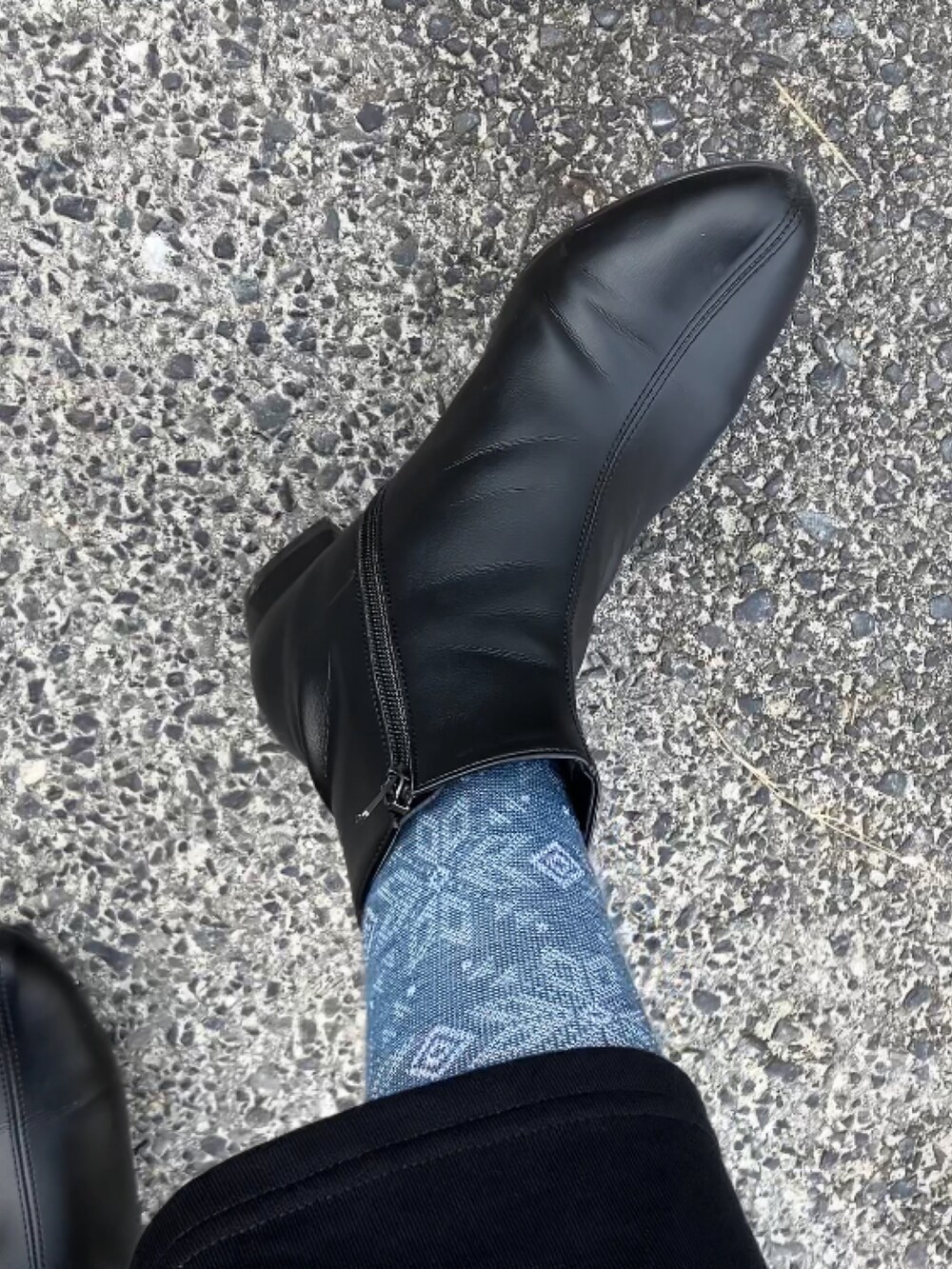 ホワイト系のダウンベスト、ブラック系のワンピース、グレー系のニット/セーターを着用したレディースの冬コーディネートの3枚目の写真