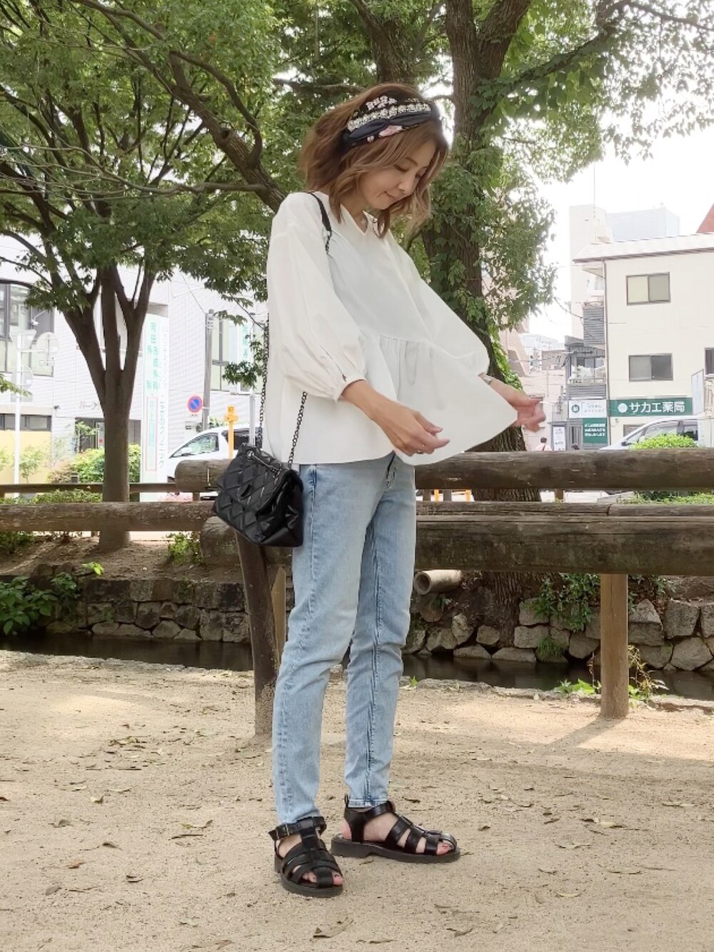 ホワイト系のシャツ/ブラウス、ブルー系のデニムパンツ、ブラック系のサンダルを着用したレディースの夏コーディネートの2枚目の写真