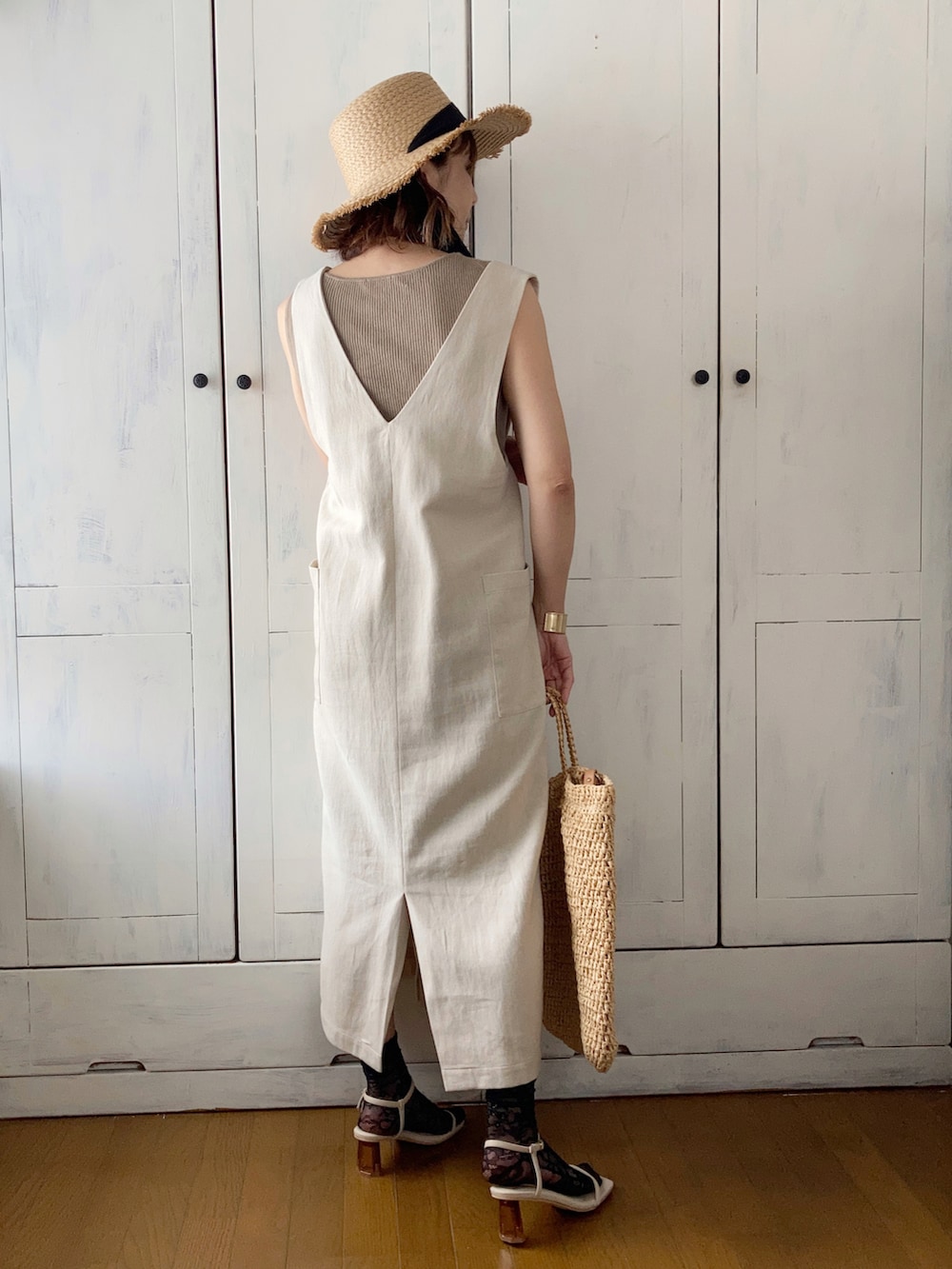 ベージュ系のジャンパースカート、ベージュ系のバッグ、ベージュ系のサンダルを着用したレディースの春コーディネートの2枚目の写真