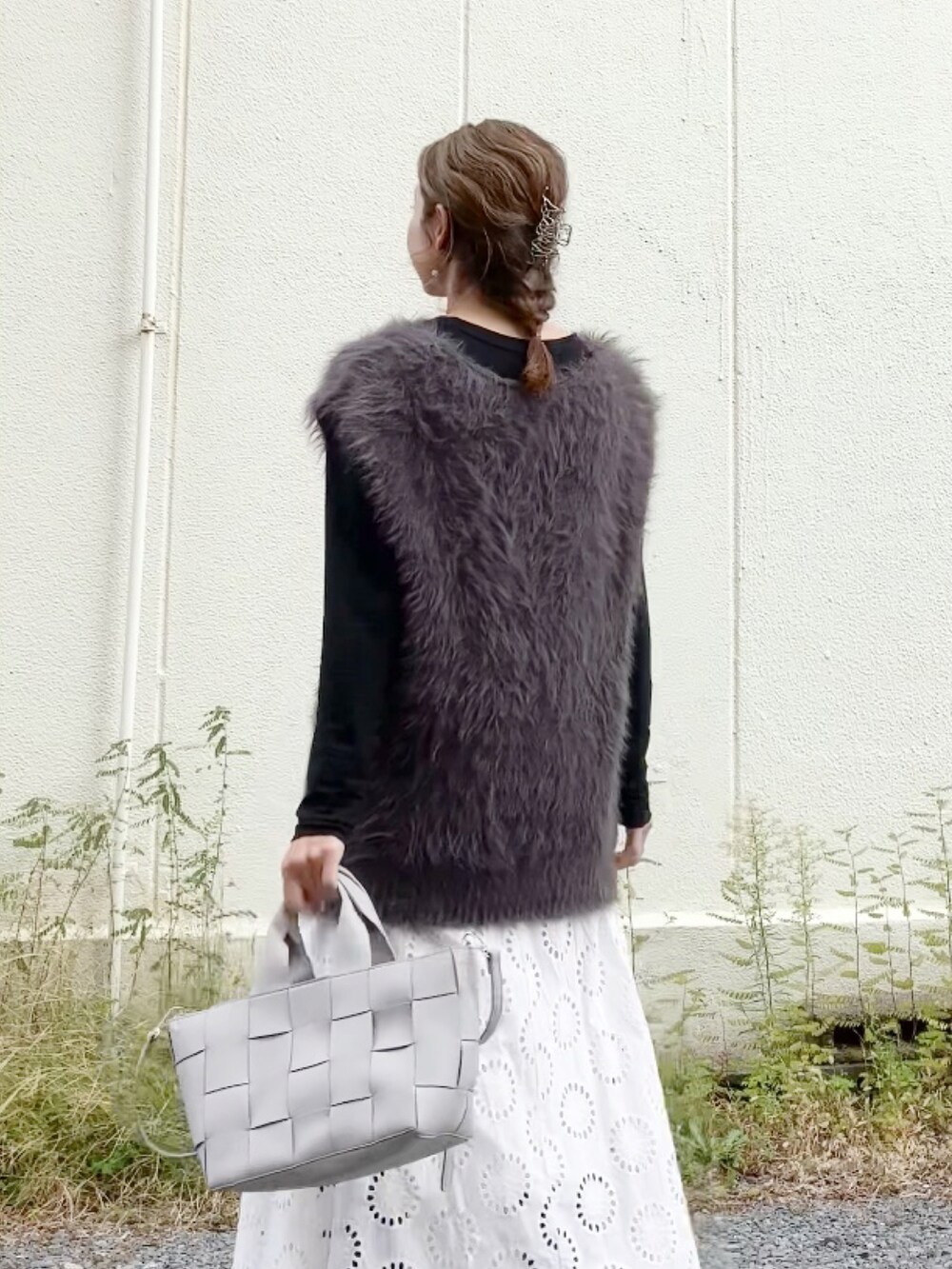 グレー系のニット/セーター、ブラック系のTシャツ/カットソー、グレー系のハンドバッグを着用したレディースの秋コーディネートの5枚目の写真