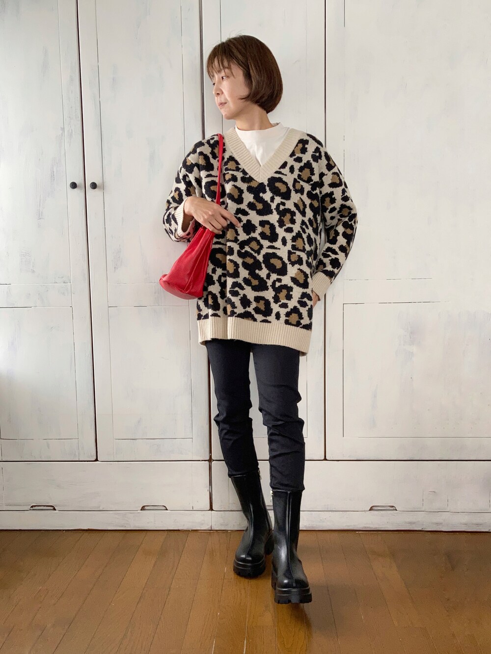 ブラック系のダウンジャケット/コート、ベージュ系のニット/セーター、ブラック系のデニムパンツを着用したレディースの秋コーディネートの2枚目の写真