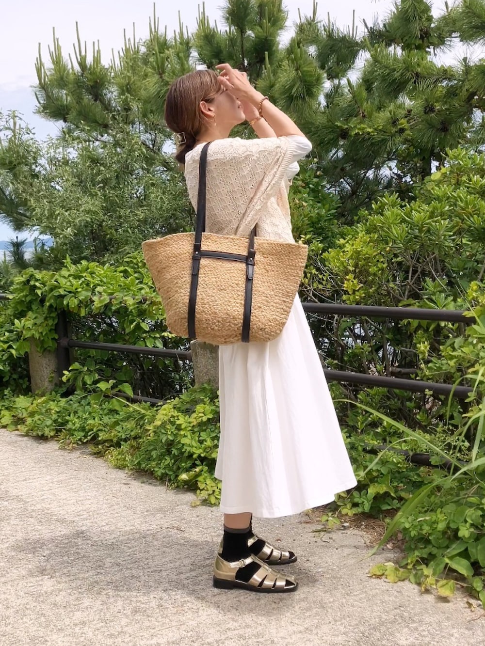 ゴールド系のサンダル、ベージュ系のニット/セーター、ベージュ系のバッグを着用したレディースの夏コーディネートの2枚目の写真