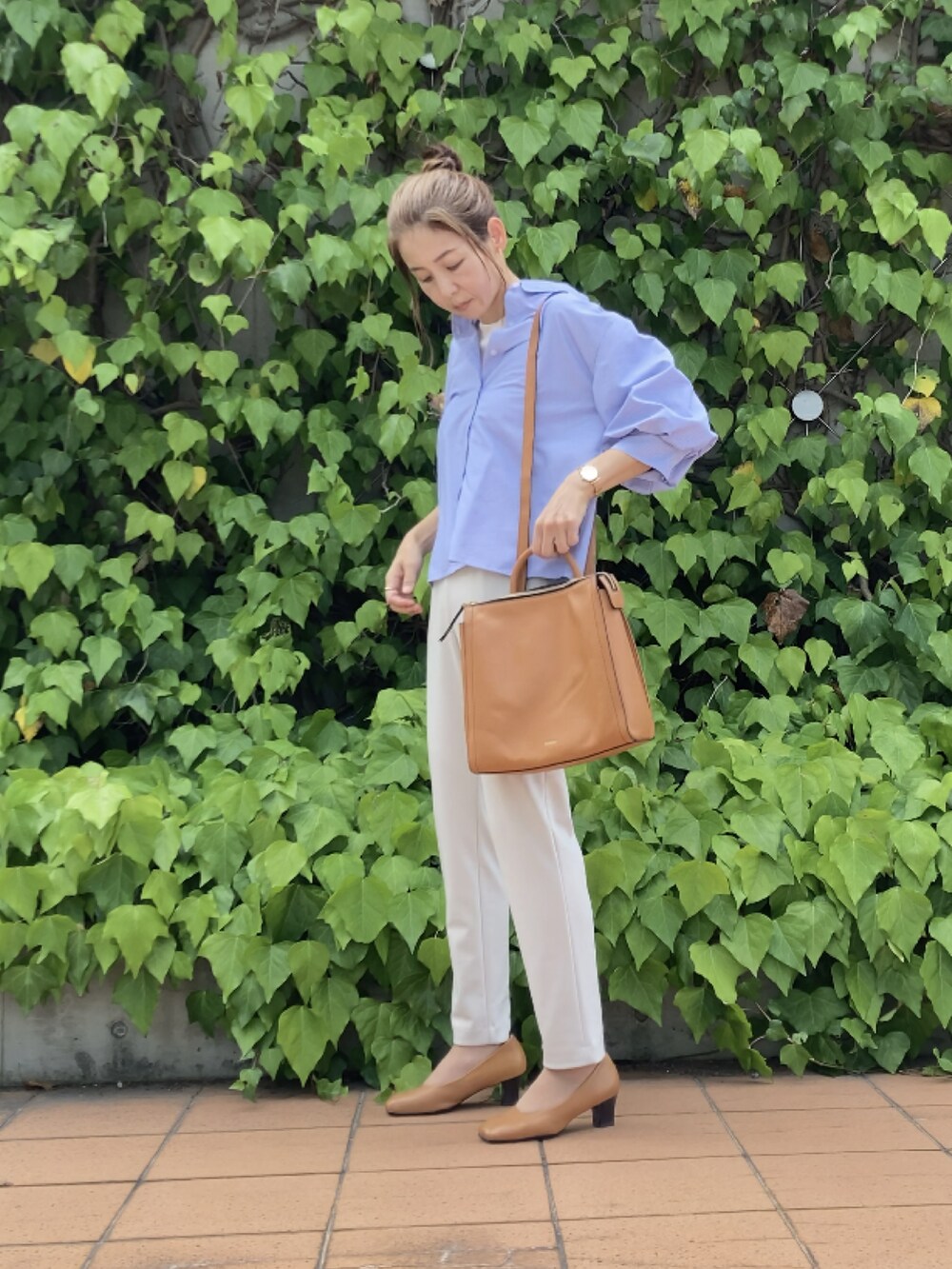 イエロー系のバックパック/リュック、ホワイト系のパンツ、ブルー系のその他トップスを着用したレディースの秋コーディネートの5枚目の写真