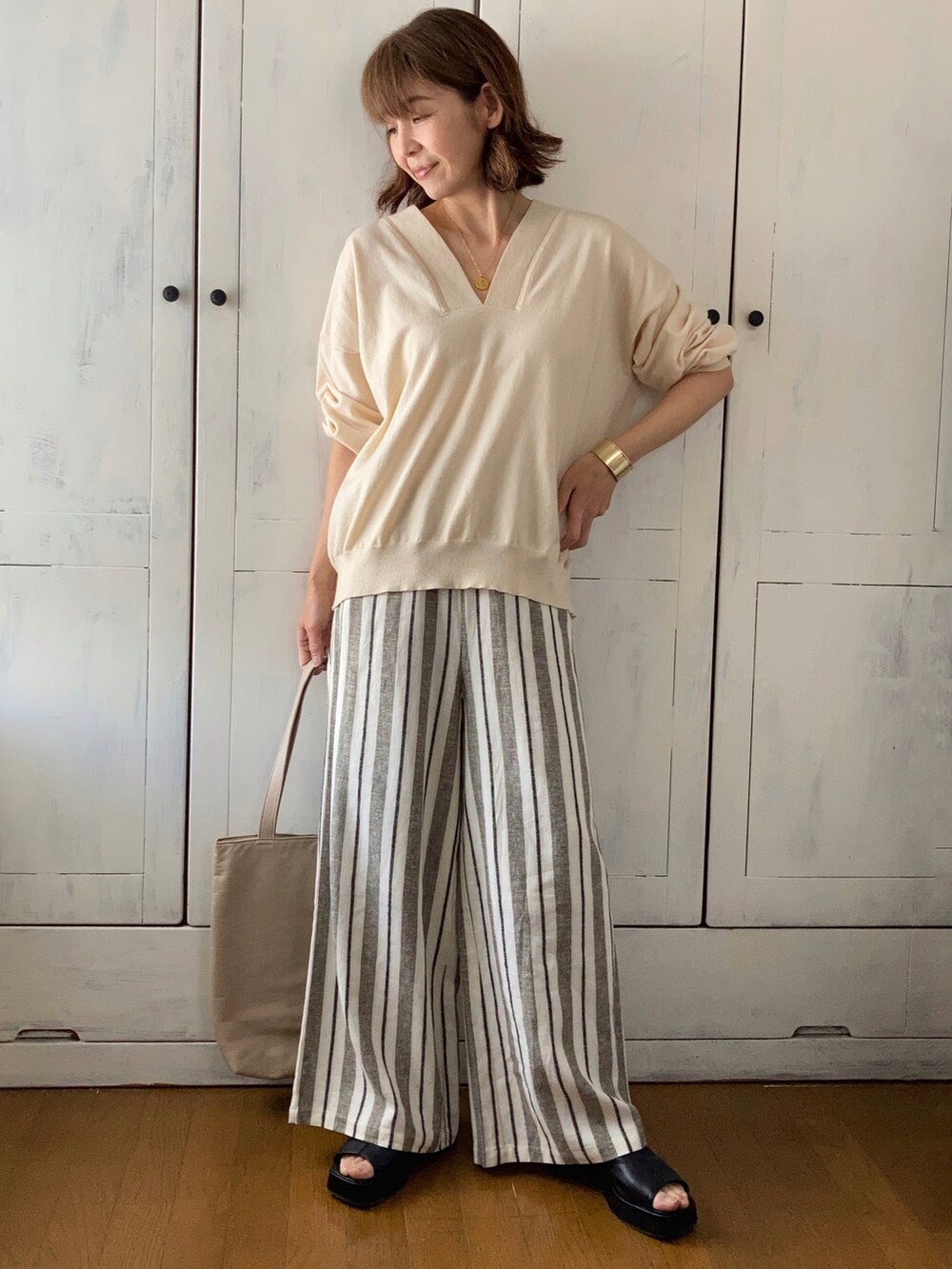 ホワイト系のニット/セーター、その他のその他パンツ、ブラック系のブーツを着用したレディースの春コーディネートの2枚目の写真