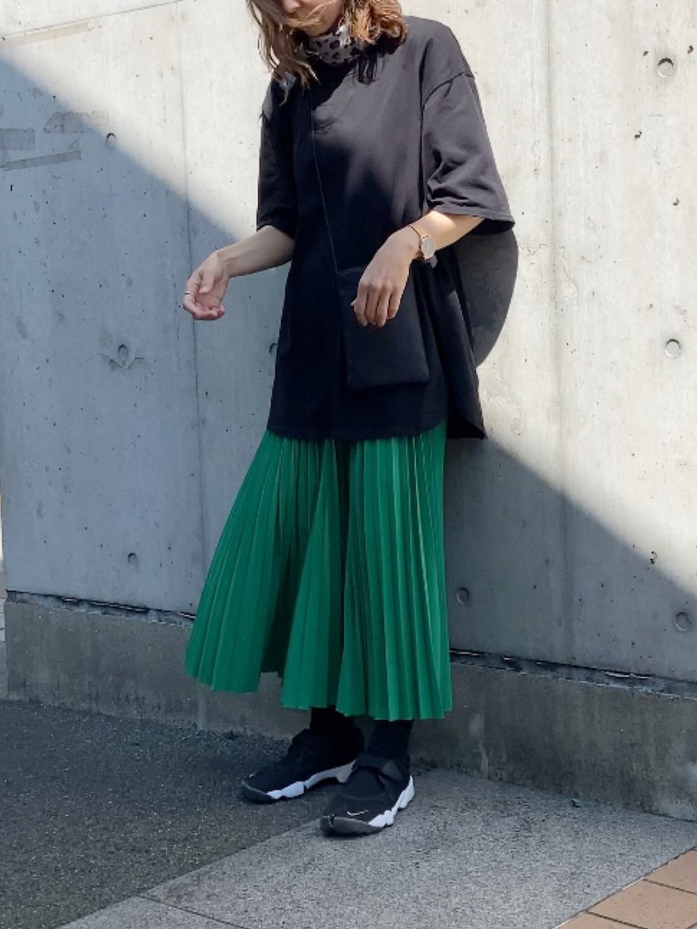 ブラック系のTシャツ/カットソー、ブラック系のバックパック/リュック、グリーン系のスカートを着用したレディースの夏コーディネートの2枚目の写真