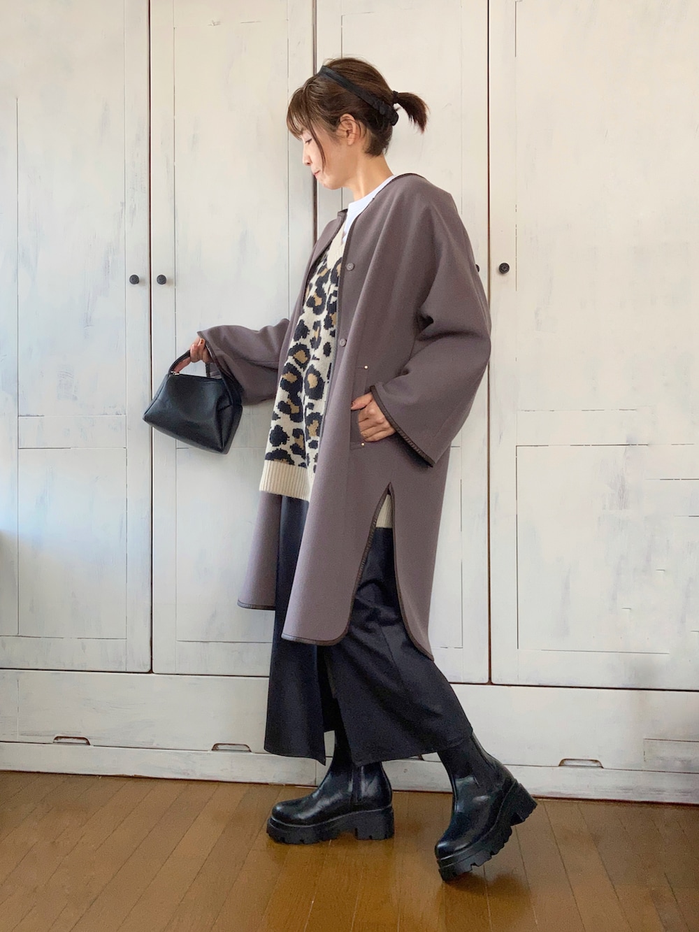 ブラウン系のその他アウター、ベージュ系のニット/セーター、ブラック系のスカートを着用したレディースの秋コーディネートの2枚目の写真