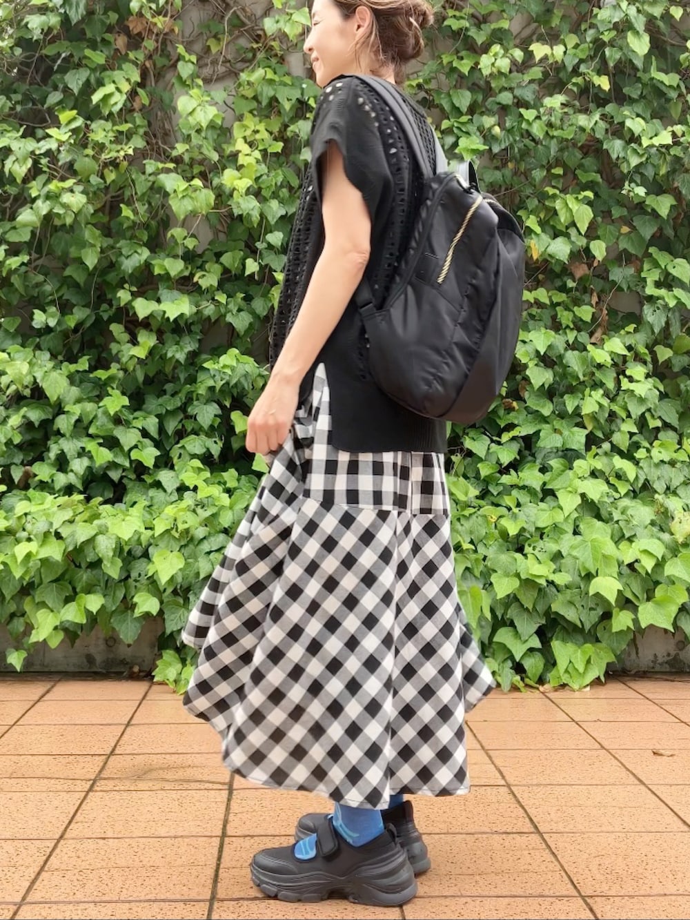 ブラック系のベスト、ブラック系のワンピース、ブラック系のシューズを着用したレディースの夏コーディネートの2枚目の写真