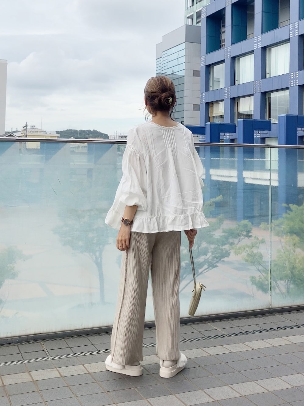 ベージュ系のその他パンツ、ゴールド系のバッグ、ホワイト系のサンダルを着用したレディースの秋コーディネートの2枚目の写真