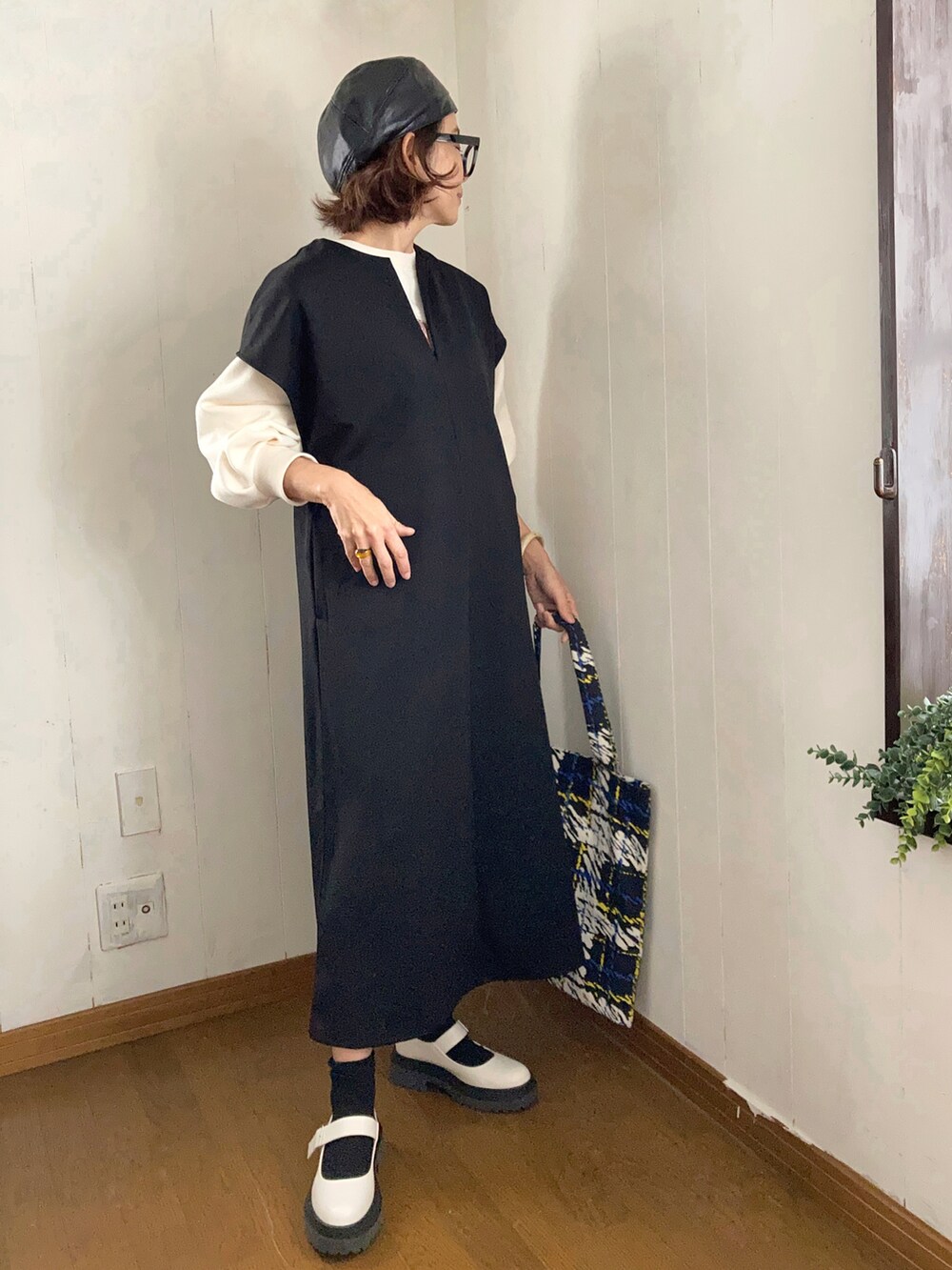 ブラック系のワンピース、ホワイト系のスウェット、ブラック系のトートバッグを着用したレディースの冬コーディネートの2枚目の写真