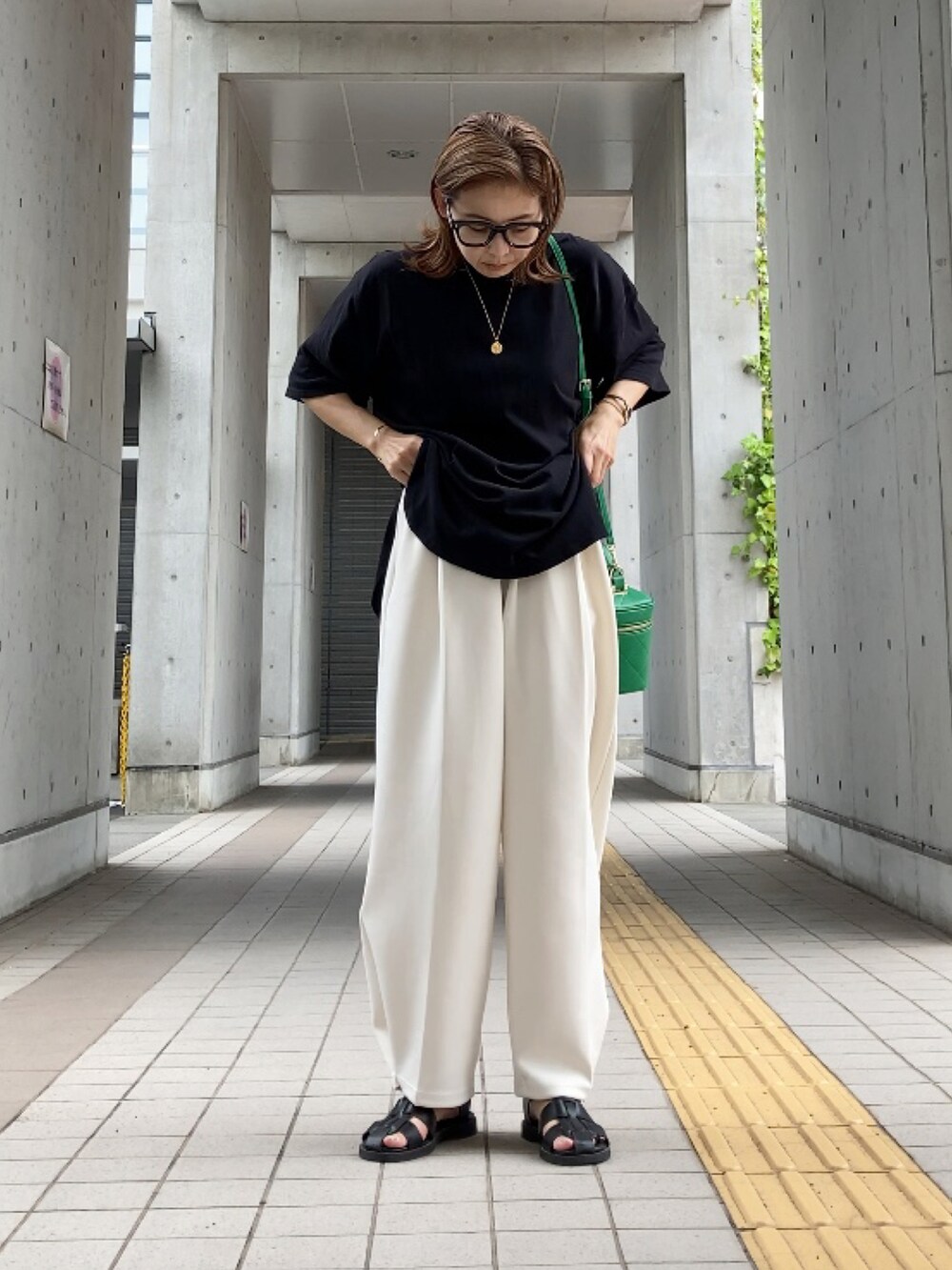 ブラック系のTシャツ/カットソー、ホワイト系のその他パンツ、グリーン系のショルダーバッグを着用したレディースの夏コーディネートの2枚目の写真