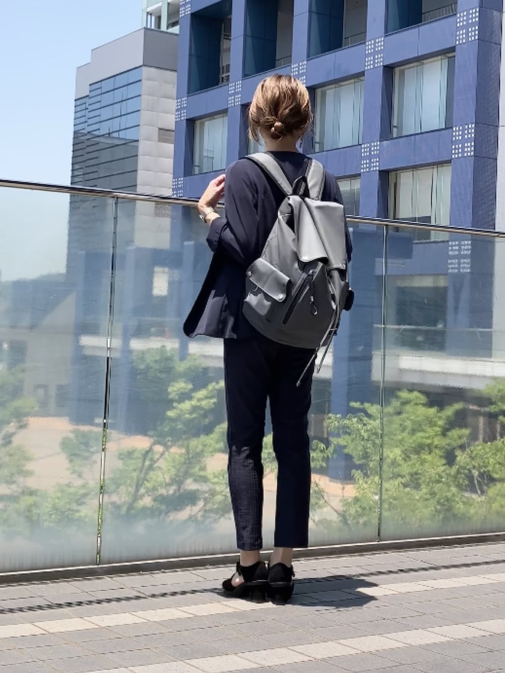 グレー系のバックパック/リュック、ホワイト系のTシャツ/カットソー、ブルー系のスーツセットを着用したレディースの夏コーディネートの2枚目の写真