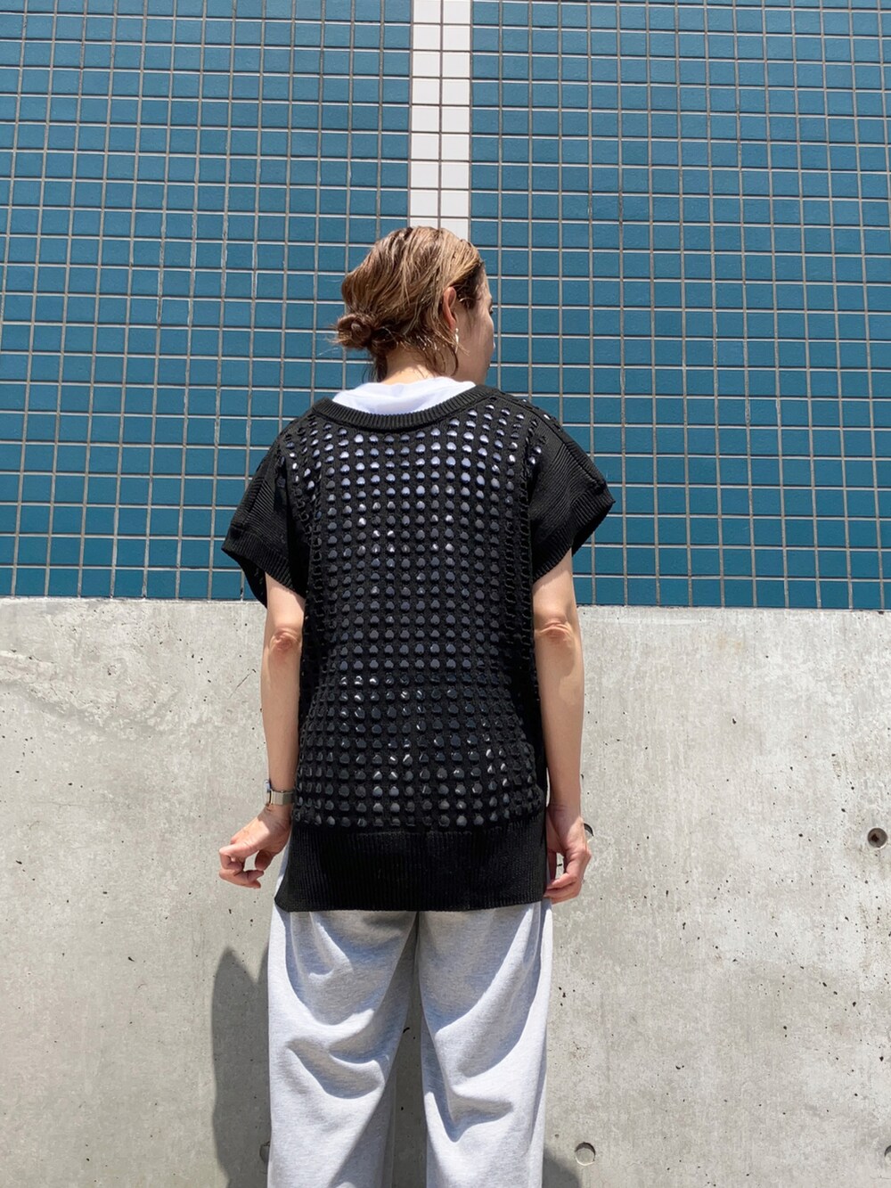 ブラック系のベスト、グレー系のスウェットパンツを着用したレディースの春コーディネートの2枚目の写真