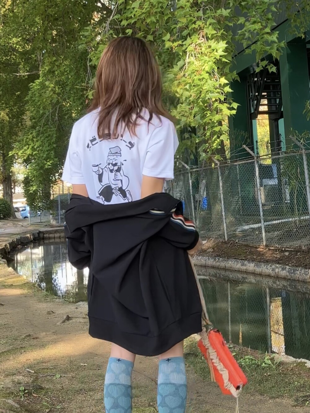 ブラック系のジャージ、オレンジ系のショルダーバッグ、ブラック系のレギンス/スパッツを着用したレディースの秋コーディネートの3枚目の写真