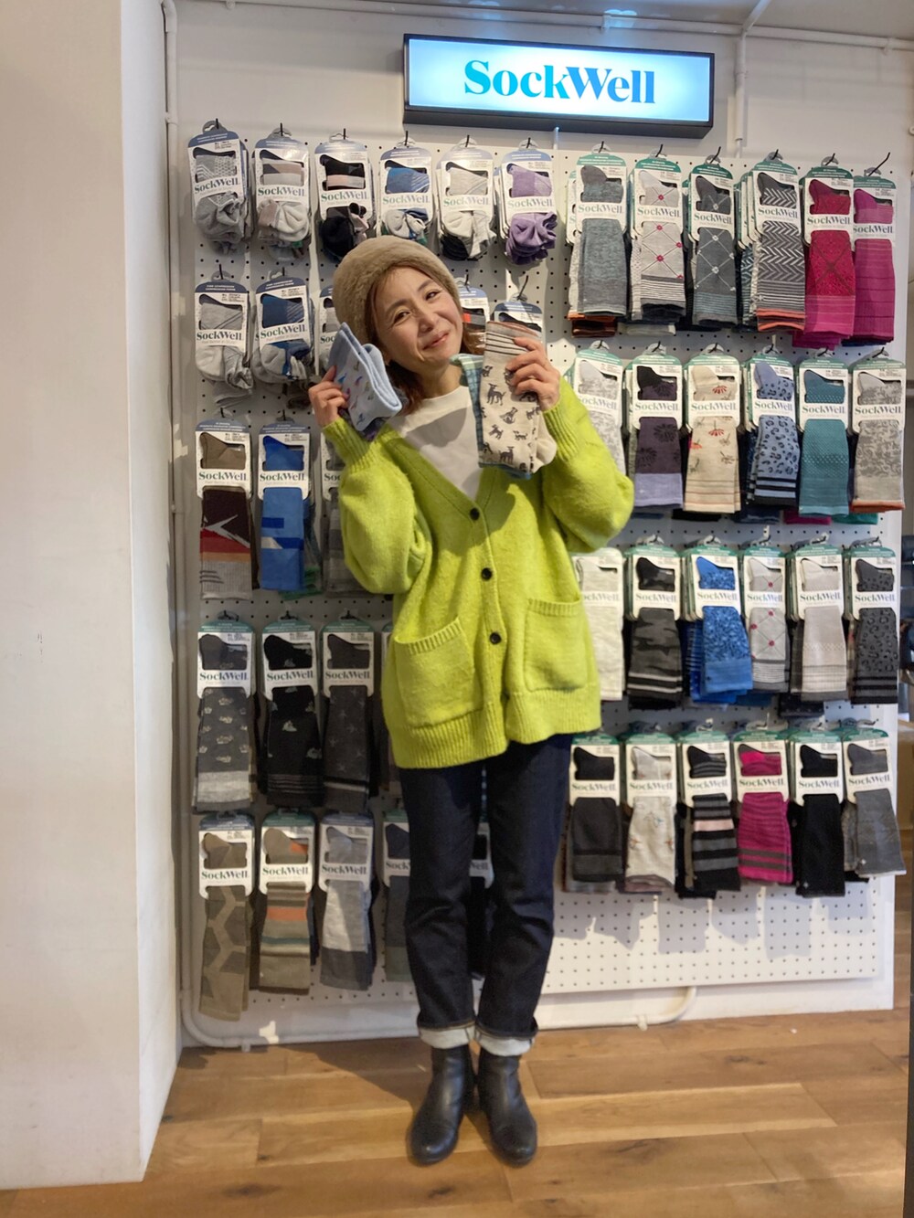 グリーン系のカーディガン/ボレロ、ブラック系のその他アウター、ブルー系のデニムパンツを着用したレディースの冬コーディネートの4枚目の写真