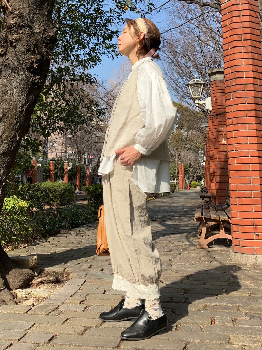 ベージュ系のベスト、ベージュ系のパンツ、ホワイト系のシャツ/ブラウスを着用したレディースの冬コーディネートの5枚目の写真