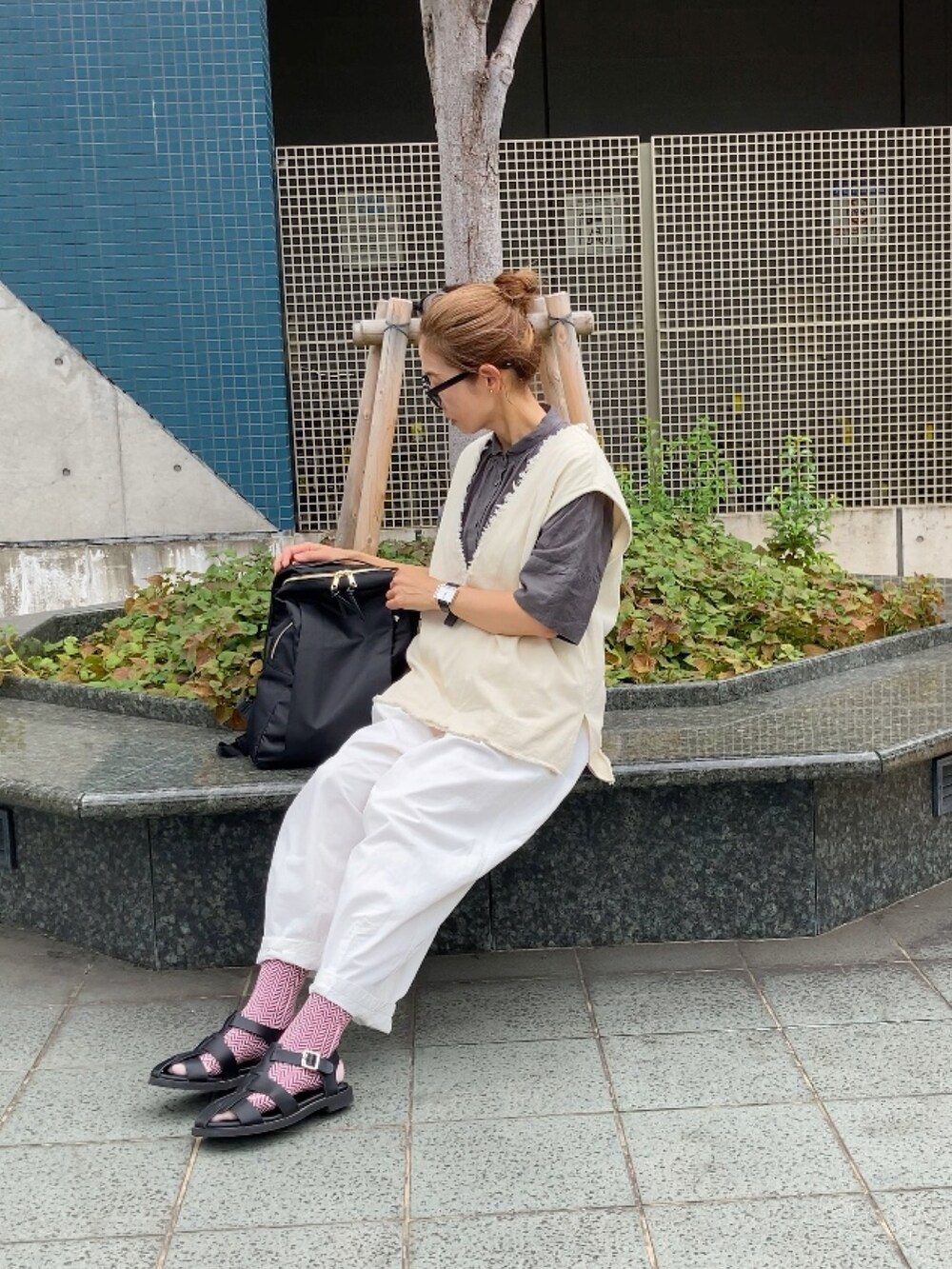 ベージュ系のベスト、グレー系のシャツ/ブラウス、ホワイト系のチノパンツを着用したレディースの夏コーディネートの2枚目の写真