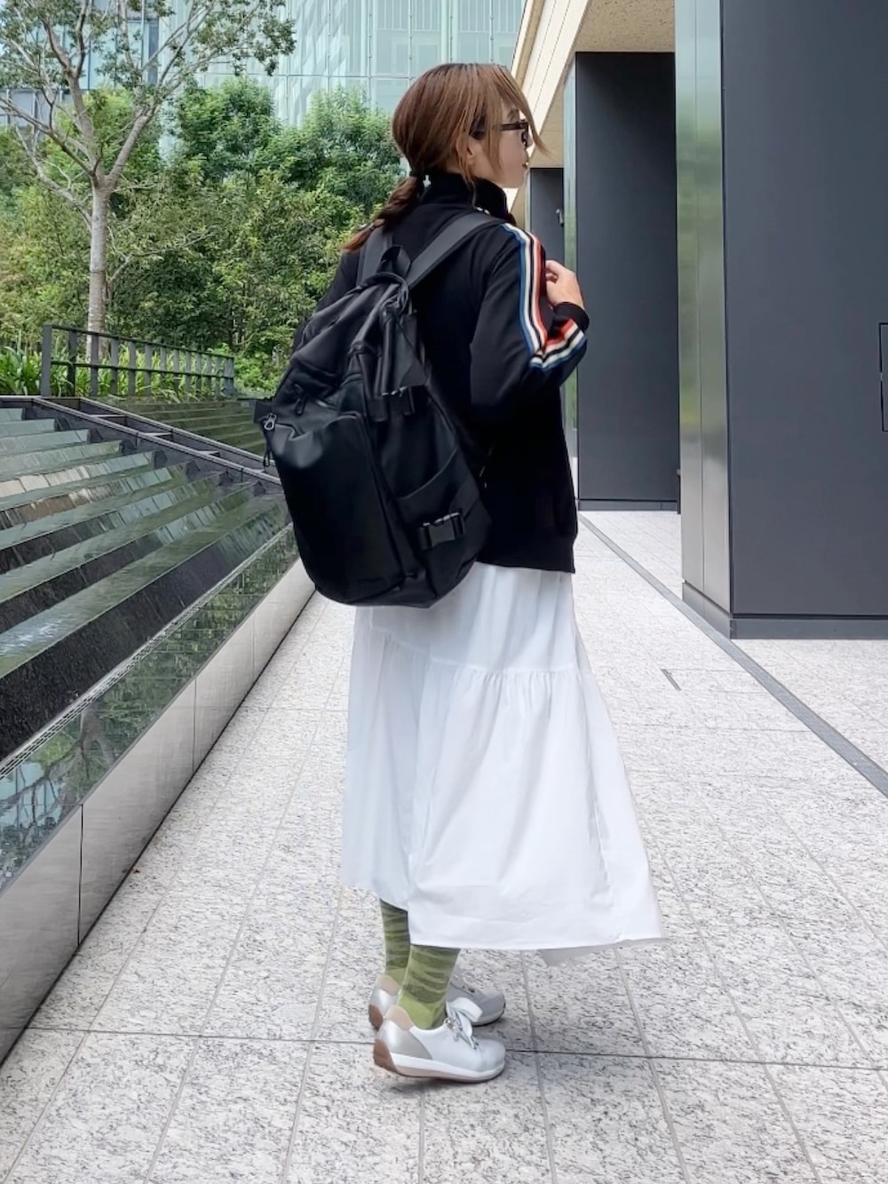ブラック系のジャージ、ブラック系のバックパック/リュック、ホワイト系のスニーカーを着用したレディースの秋コーディネートの3枚目の写真