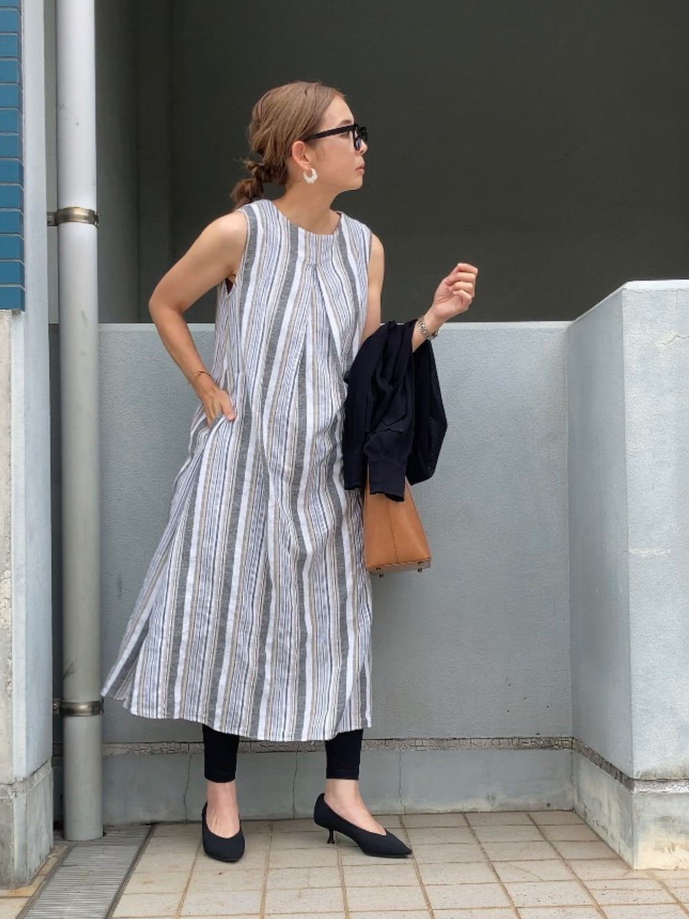 ホワイト系のワンピース、ブルー系のデニムパンツ、イエロー系のサンダルを着用したレディースの夏コーディネートの4枚目の写真