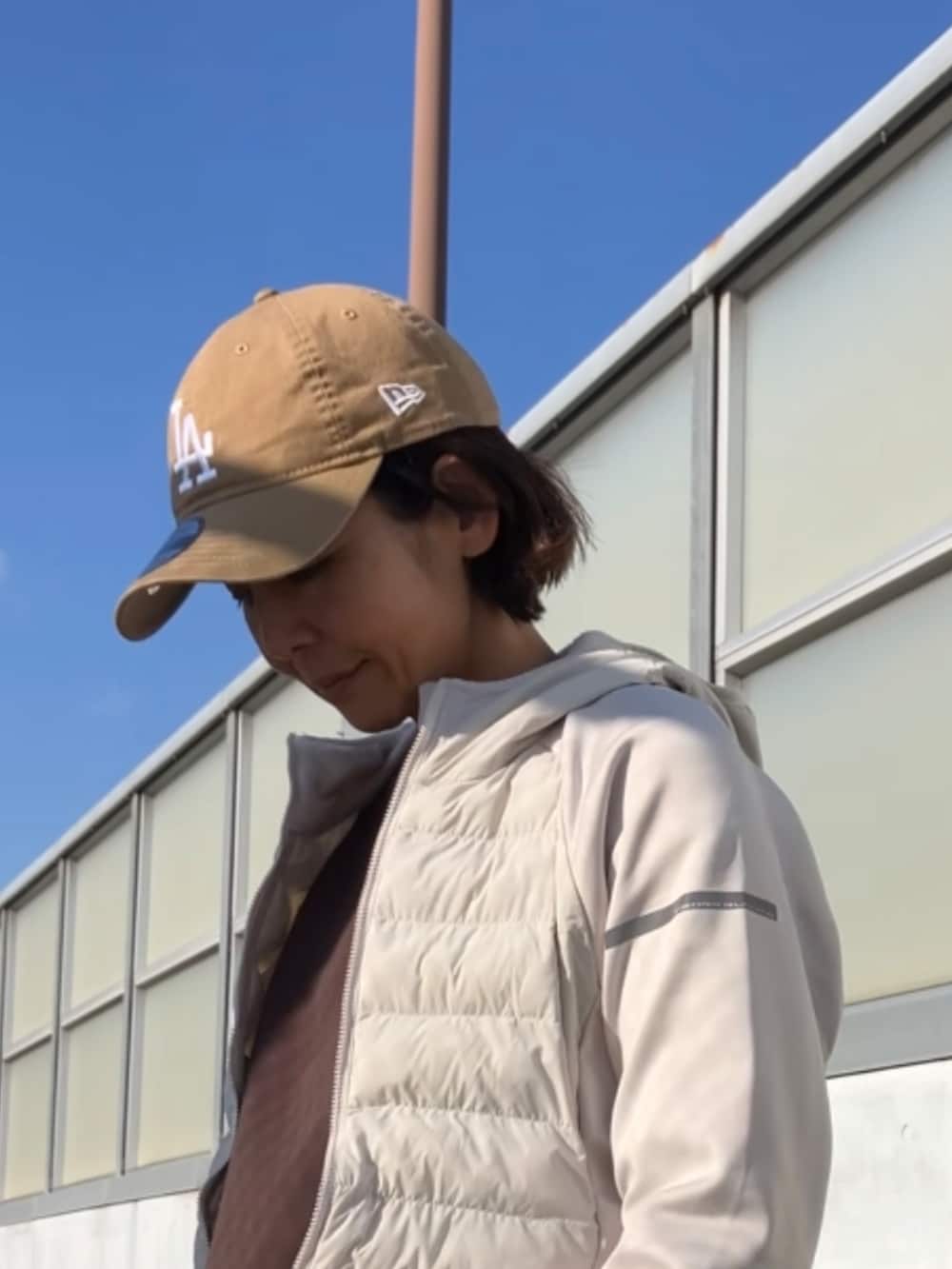 ホワイト系のその他アウター、ベージュ系のキャップを着用したレディースの冬コーディネートの2枚目の写真