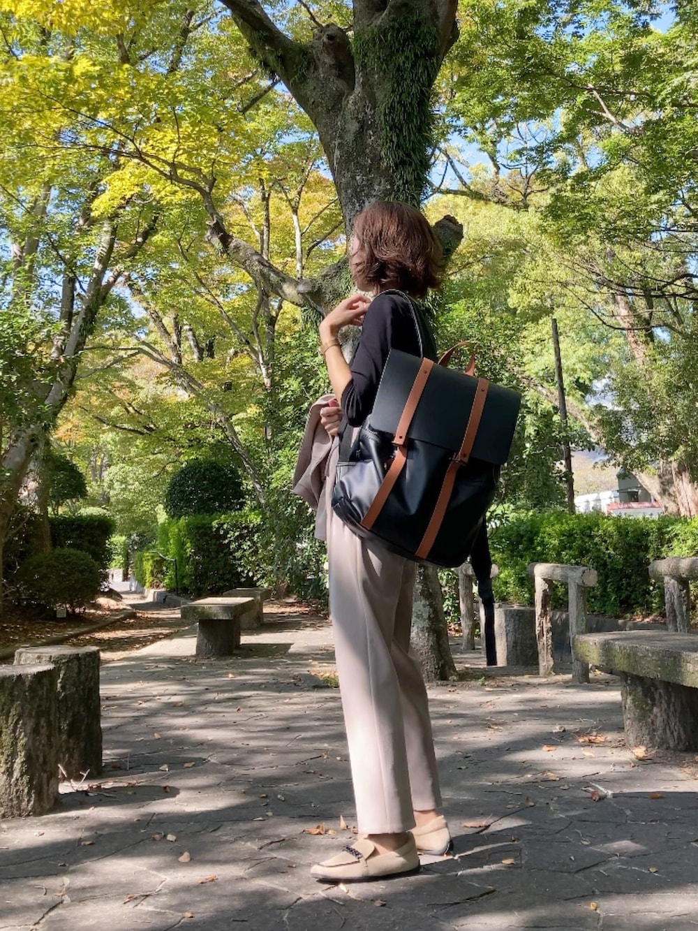 ベージュ系のスーツセット、ベージュ系のシューズ、ブラウン系のバックパック/リュックを着用したレディースの秋コーディネートの4枚目の写真