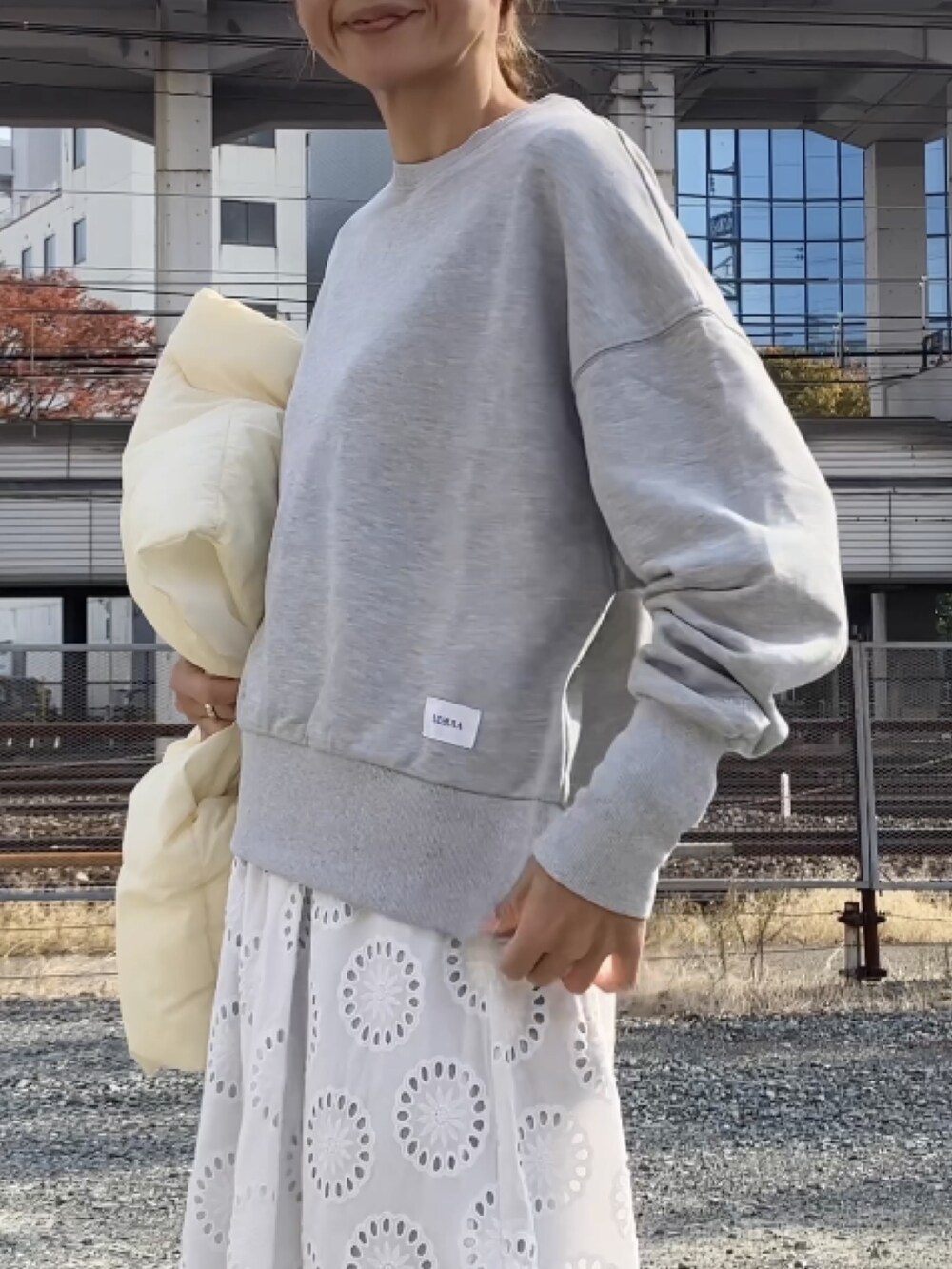 グレー系のスウェット、ホワイト系のダウンベスト、ホワイト系のバレッタ/ヘアクリップを着用したレディースの秋コーディネートの2枚目の写真