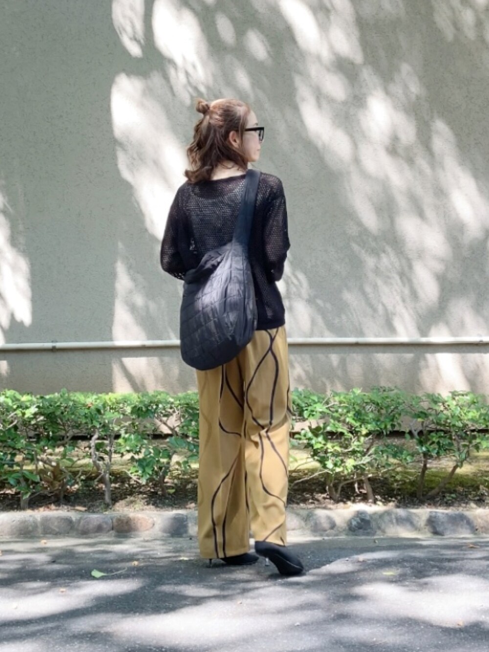 ブラック系のショルダーバッグ、イエロー系のその他パンツ、ブラック系のパンプスを着用したレディースの秋コーディネートの2枚目の写真