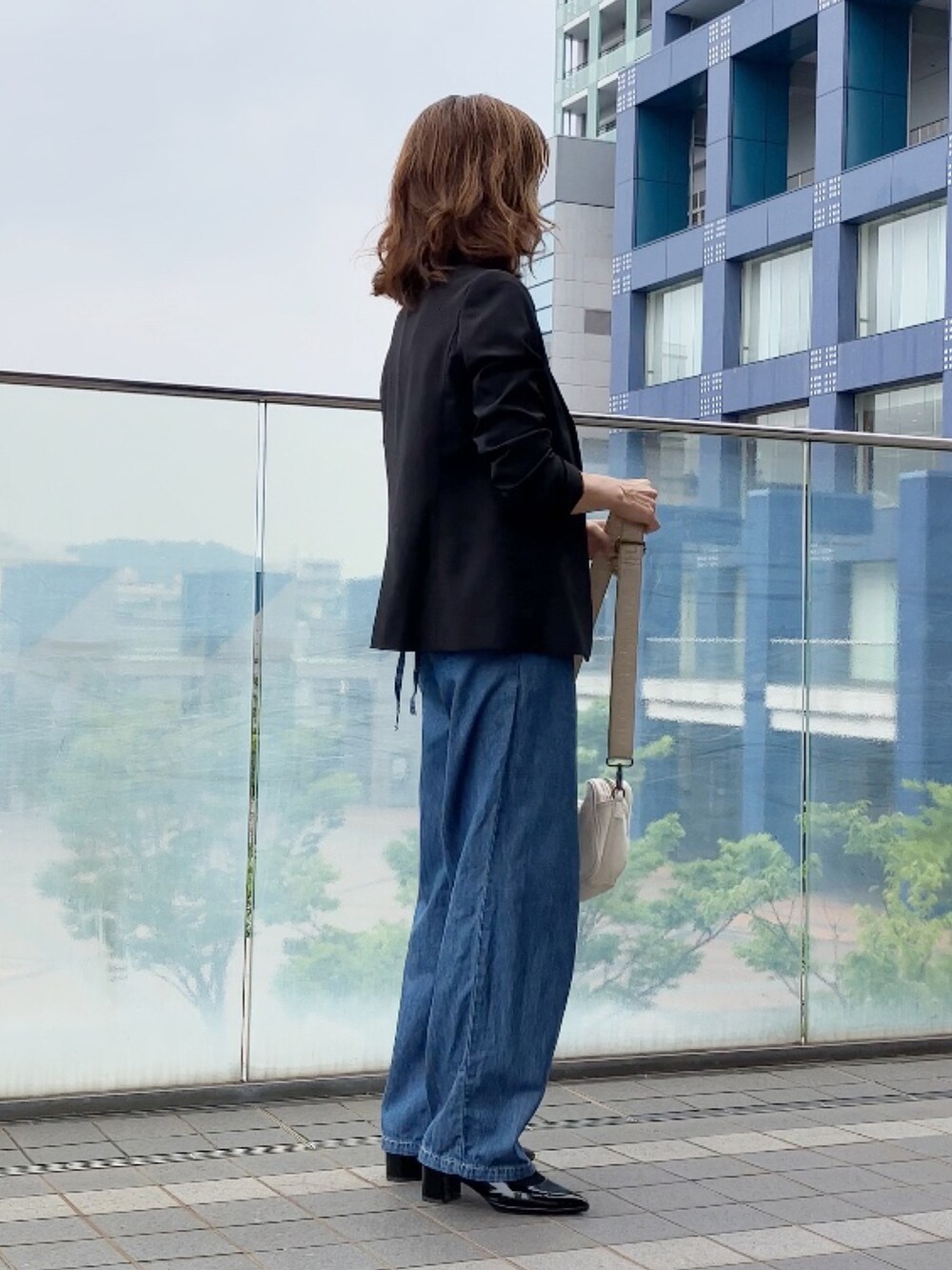 ブルー系のサロペット/オーバーオール、ホワイト系のTシャツ/カットソー、ブラック系のスーツセットを着用したレディースの夏コーディネートの3枚目の写真