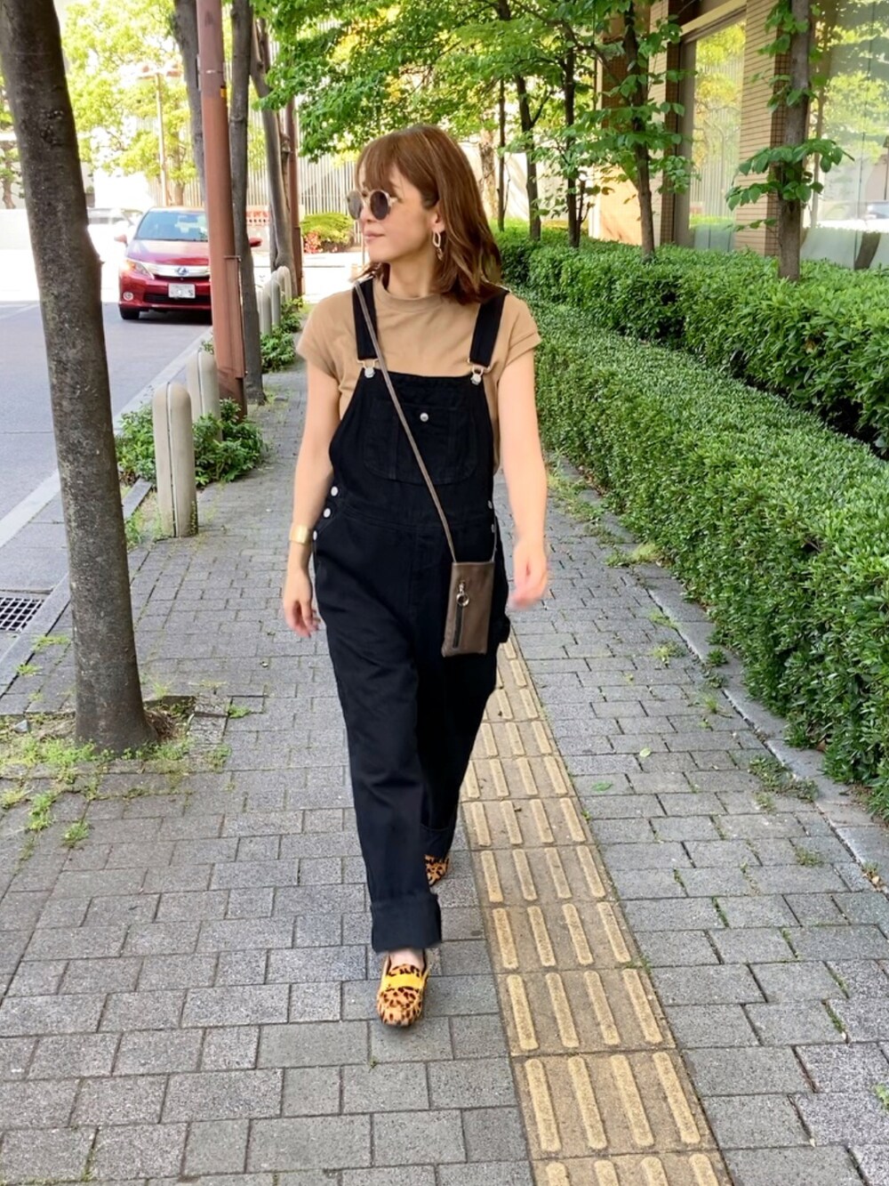 ベージュ系のローファー、ブラック系のサロペット/オーバーオール、ベージュ系のTシャツ/カットソーを着用したレディースの春コーディネートの4枚目の写真