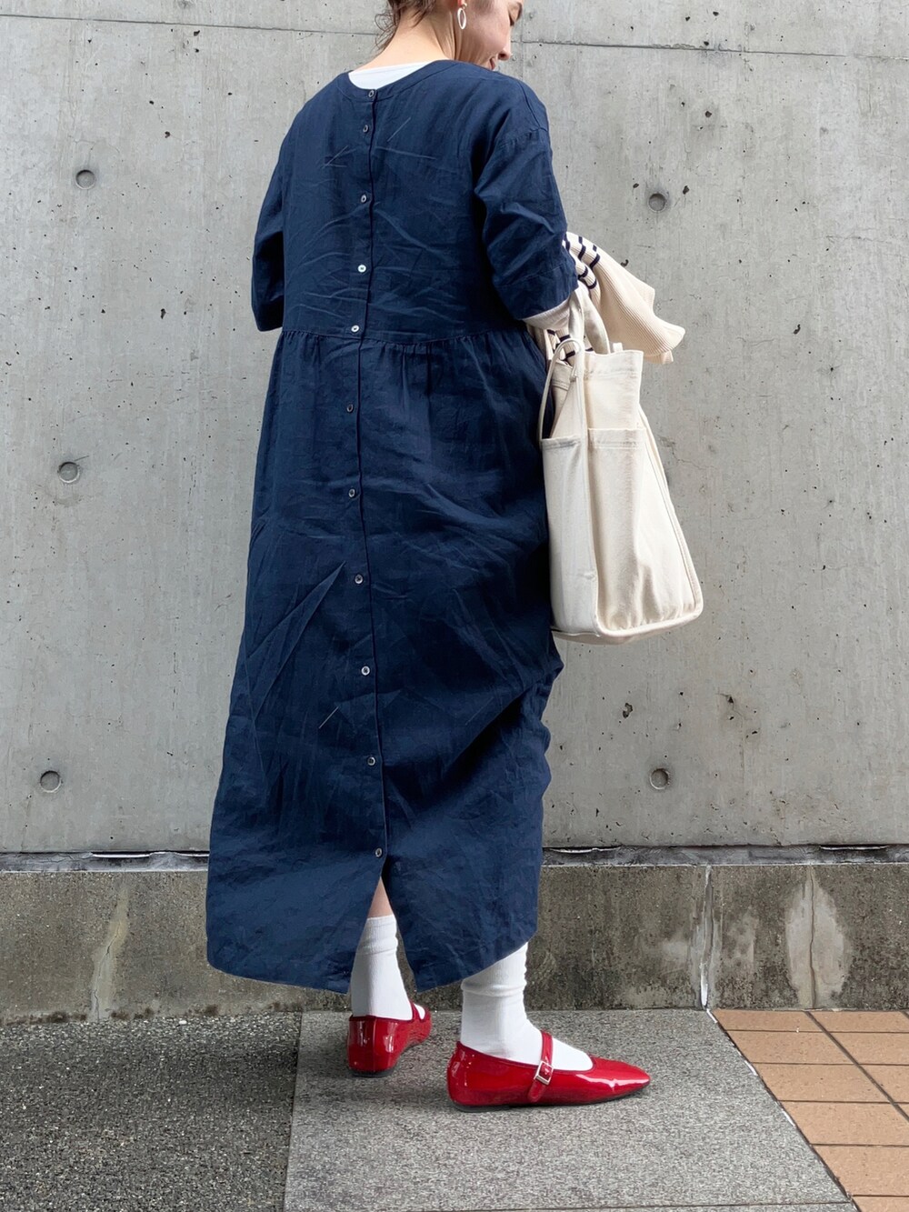 ホワイト系のトートバッグ、レッド系のパンプス、ブルー系のワンピース/ドレスを着用したレディースの冬コーディネートの2枚目の写真