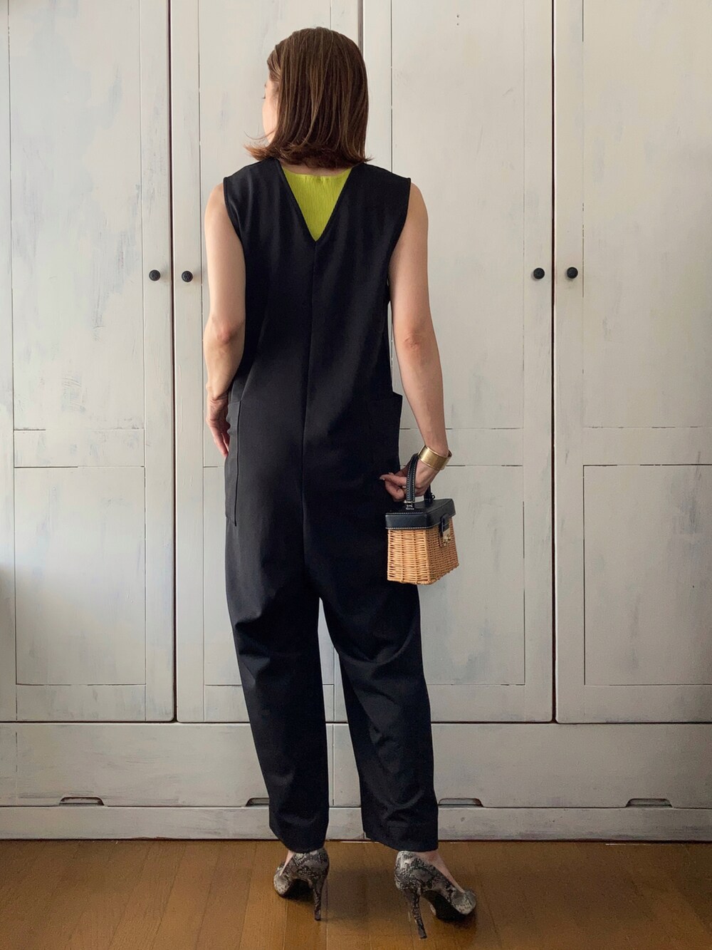 ブラック系のつなぎ/オールインワン、グリーン系のタンクトップ、ブラウン系のかごバッグを着用したレディースの春コーディネートの2枚目の写真