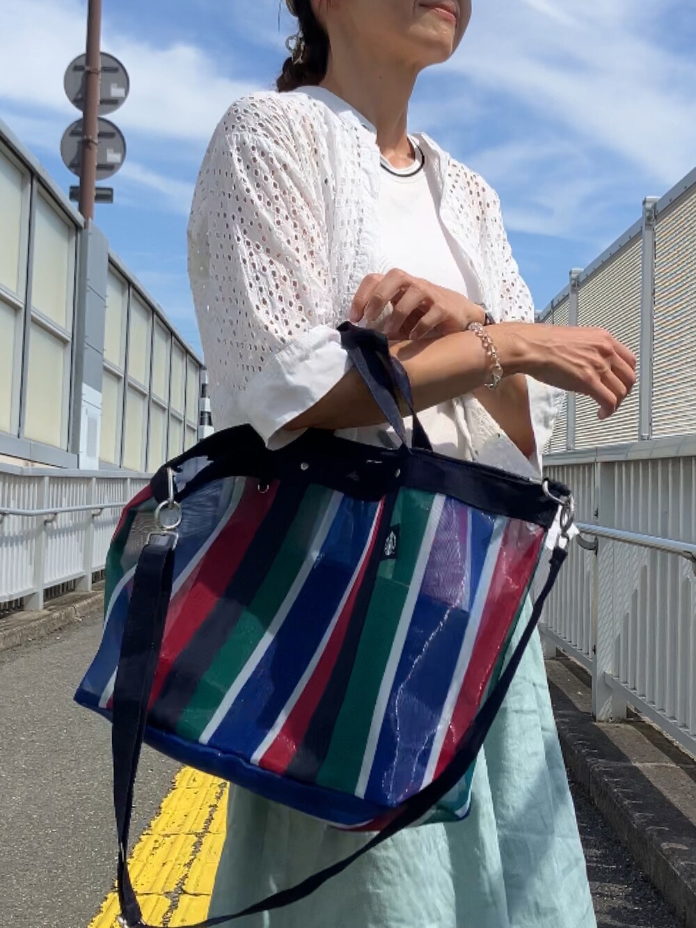 レッド系のバッグ、ベージュ系のキャップを着用したレディースの夏コーディネートの3枚目の写真