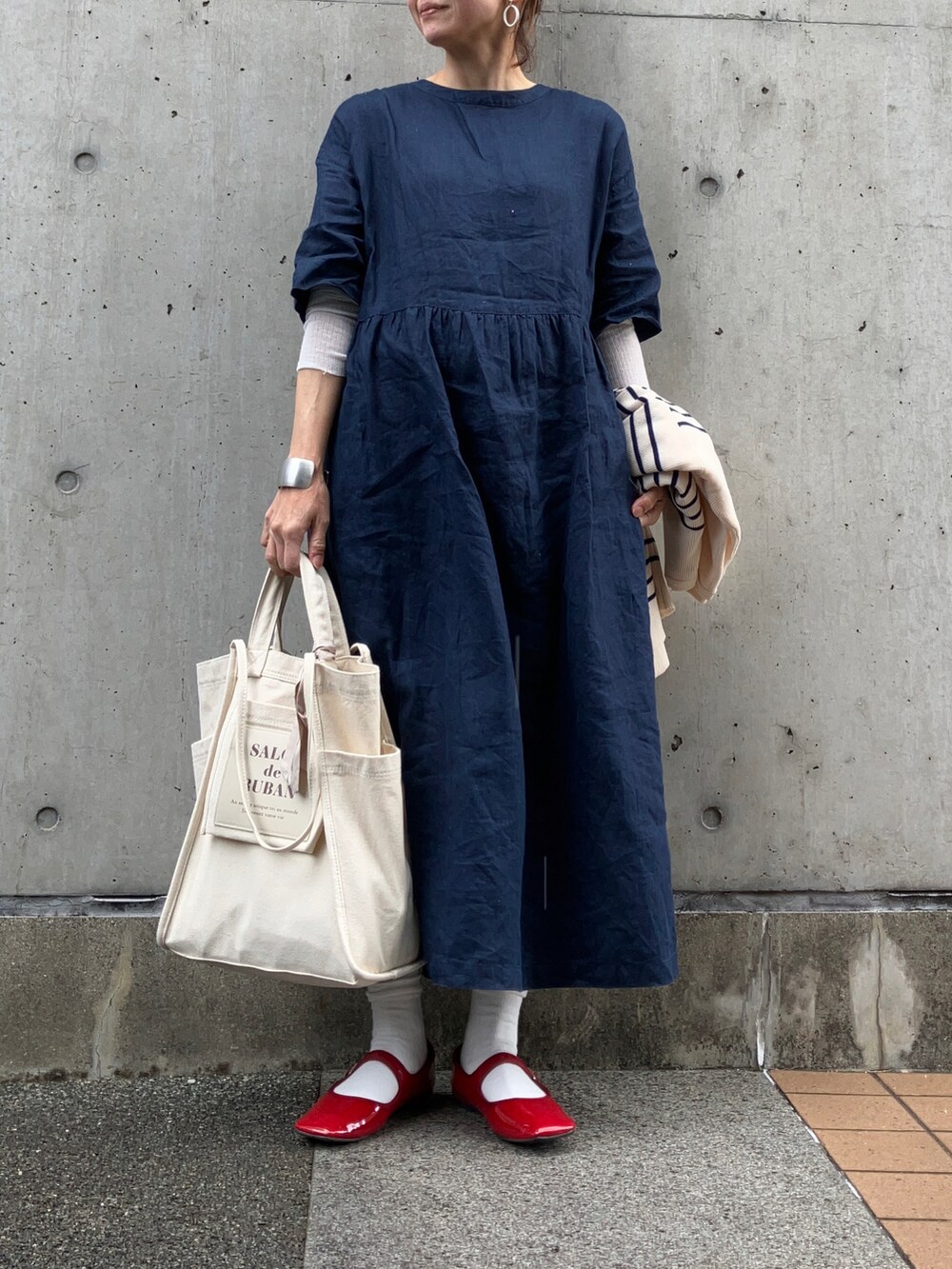 ホワイト系のトートバッグ、レッド系のパンプス、ブルー系のワンピース/ドレスを着用したレディースの冬コーディネートの5枚目の写真