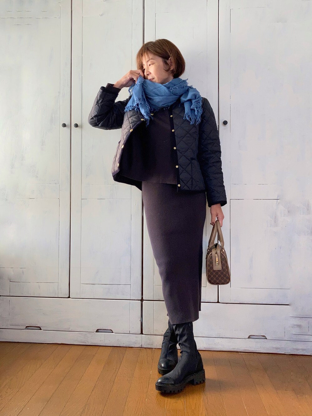 ブルー系のノーカラージャケット、グレー系のワンピース、ブラウン系のボストンバッグを着用したレディースの秋コーディネートの3枚目の写真