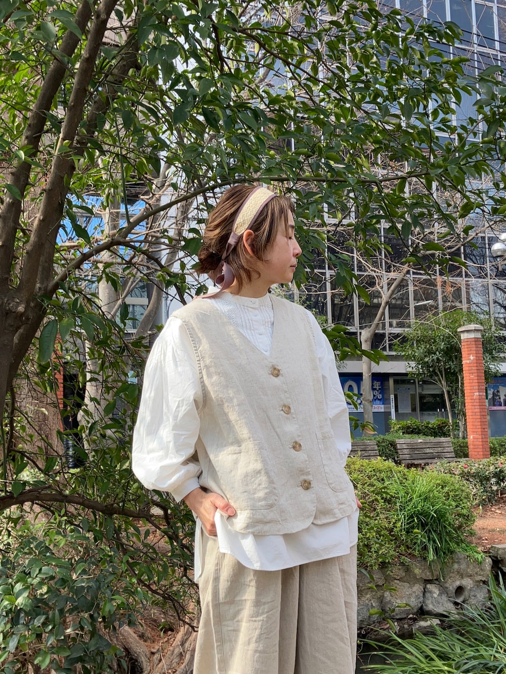 ベージュ系のベスト、ベージュ系のパンツ、ホワイト系のシャツ/ブラウスを着用したレディースの冬コーディネートの2枚目の写真