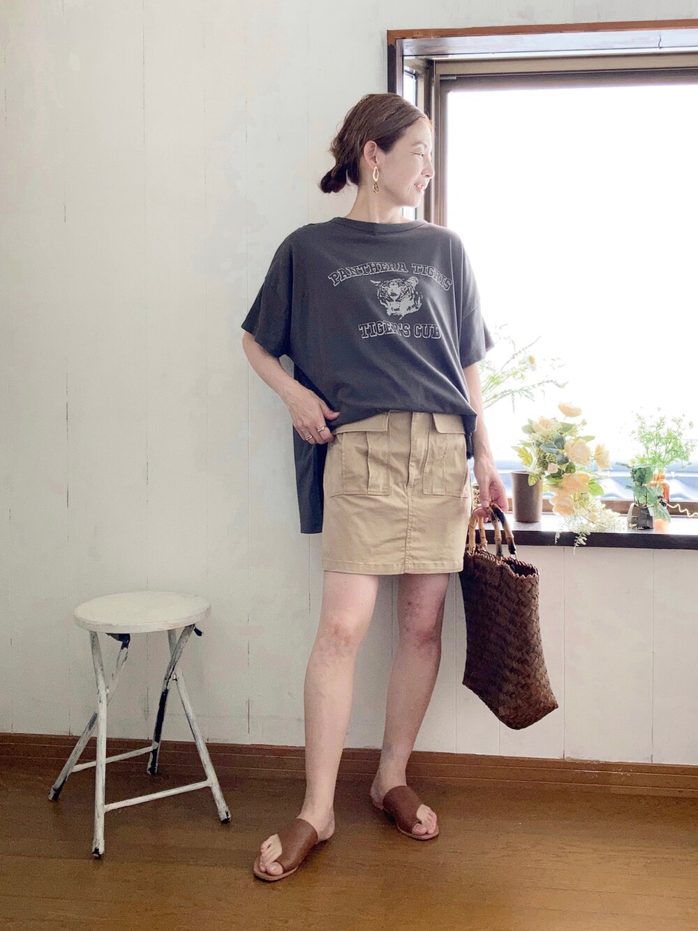 グレー系のTシャツ/カットソー、ベージュ系のスカート、ブラウン系のかごバッグを着用したレディースの夏コーディネートの2枚目の写真