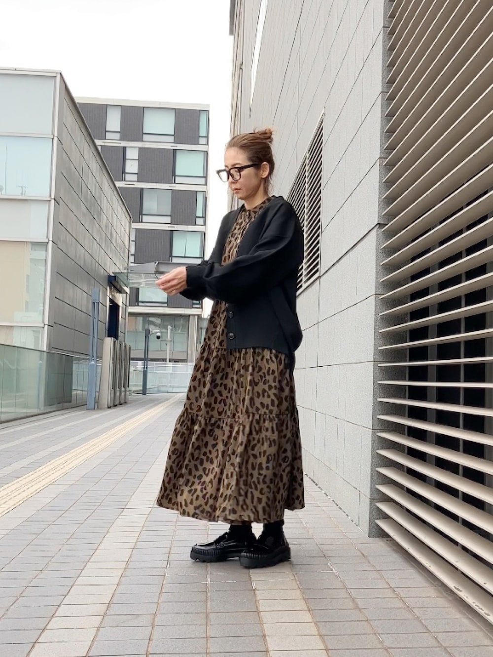 ブラウン系のワンピース、ブラック系のカーディガン/ボレロ、ブラック系のローファーを着用したレディースの冬コーディネートの3枚目の写真