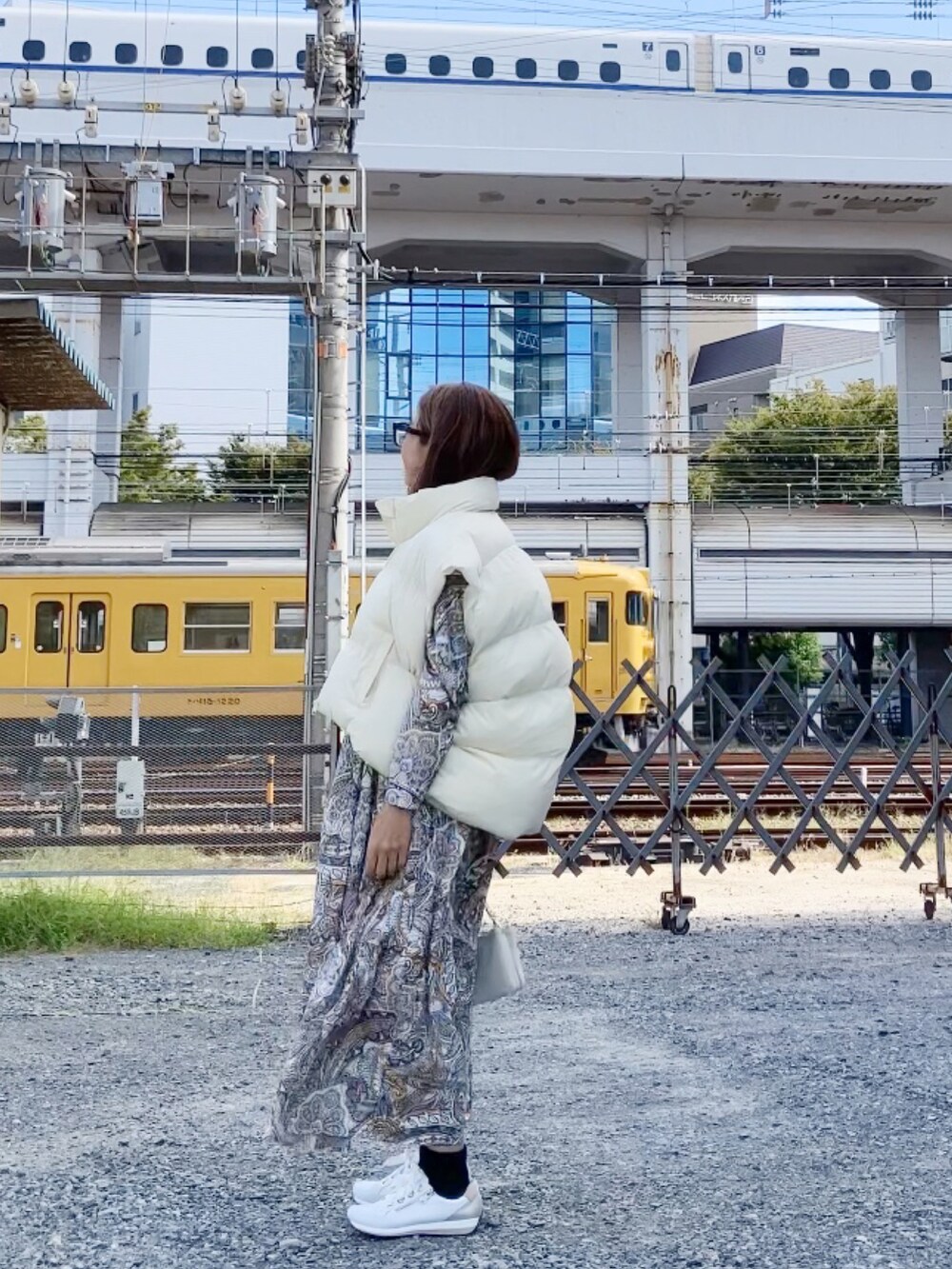 ブラック系のジャケット/アウター、ホワイト系のスニーカー、ホワイト系のショルダーバッグを着用したレディースの秋コーディネートの4枚目の写真