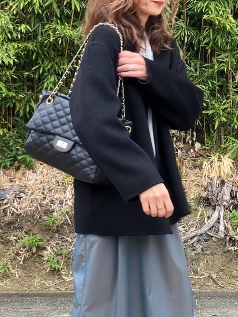 ブラック系のボストンバッグ、グレー系のスウェット、グリーン系のスカートを着用したレディースの冬コーディネートの2枚目の写真