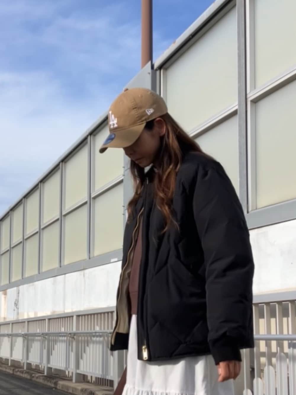 ブラック系のダウンジャケット/コート、ベージュ系のキャップを着用したレディースの冬コーディネートの3枚目の写真